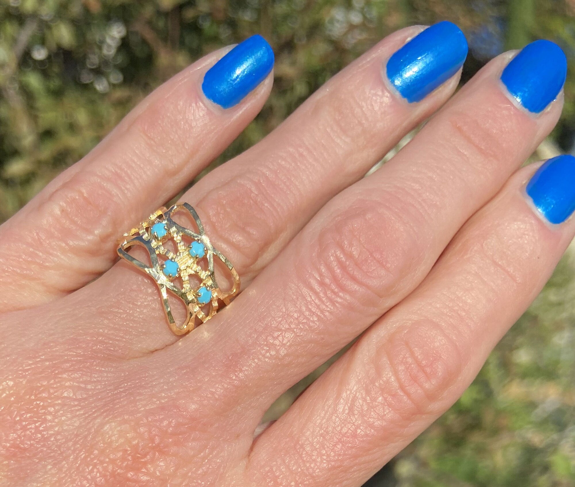 This gorgeous turquoise ring displays simple elegance in its design. The ring features a round-cut natural blue turquoise gemstones and finished with a hammered band.