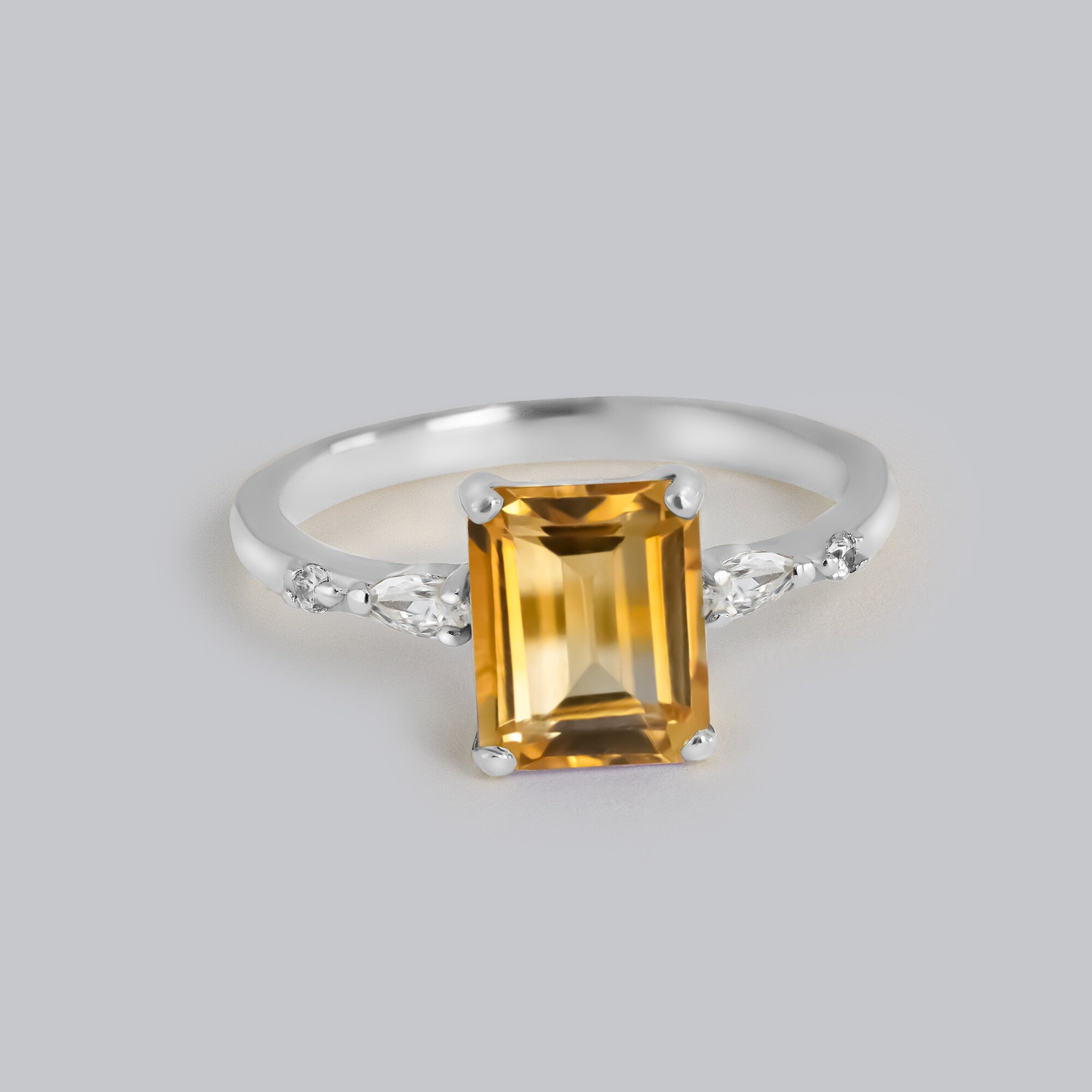 An absolute stunner, classic natural citrine engagement ring with an emerald cut gemstone of your choice as it’s centre stone and with clear quartz on the band to further accentuate it.