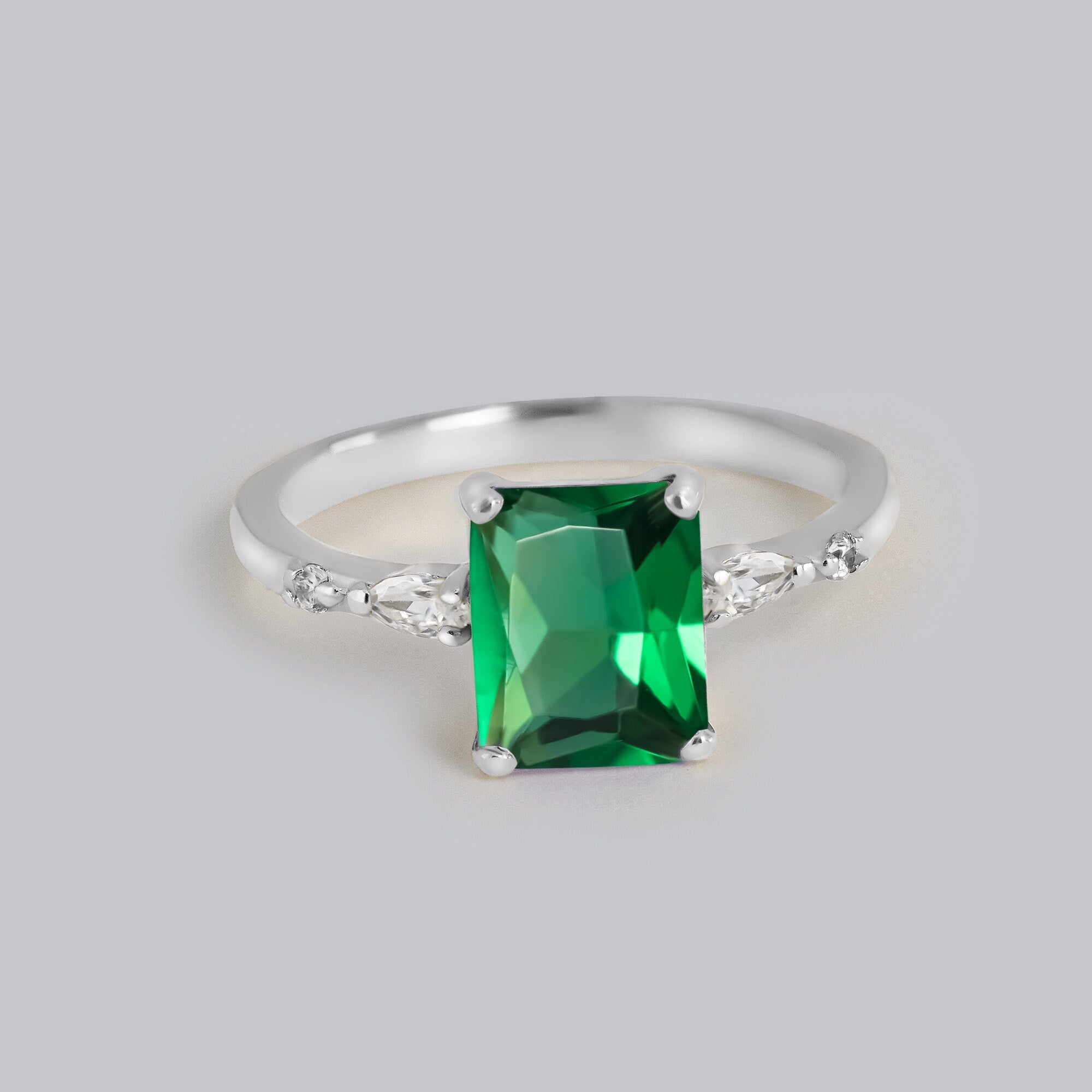 An absolute stunner, classic emerald engagement ring with an emerald cut gemstone of your choice as it’s centre stone and with clear quartz on the band to further accentuate it.