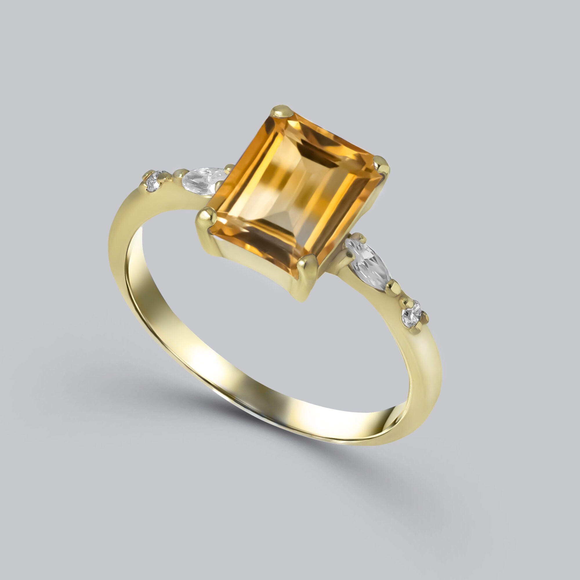 An absolute stunner, classic natural citrine engagement ring with an emerald cut gemstone of your choice as it’s centre stone and with clear quartz on the band to further accentuate it.