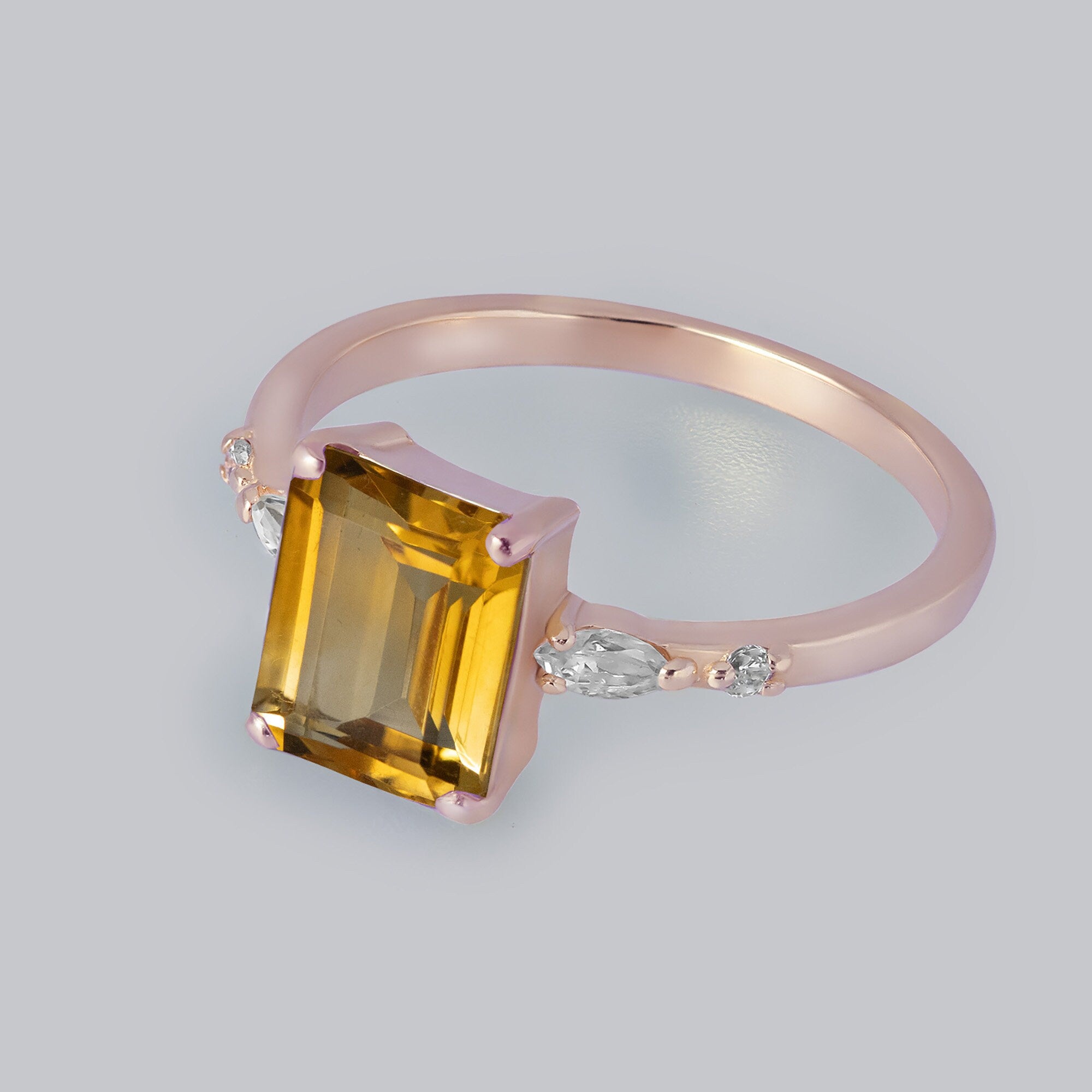 An absolute stunner, classic natural citrine engagement ring with an emerald cut gemstone of your choice as it’s centre stone and with clear quartz on the band to further accentuate it.