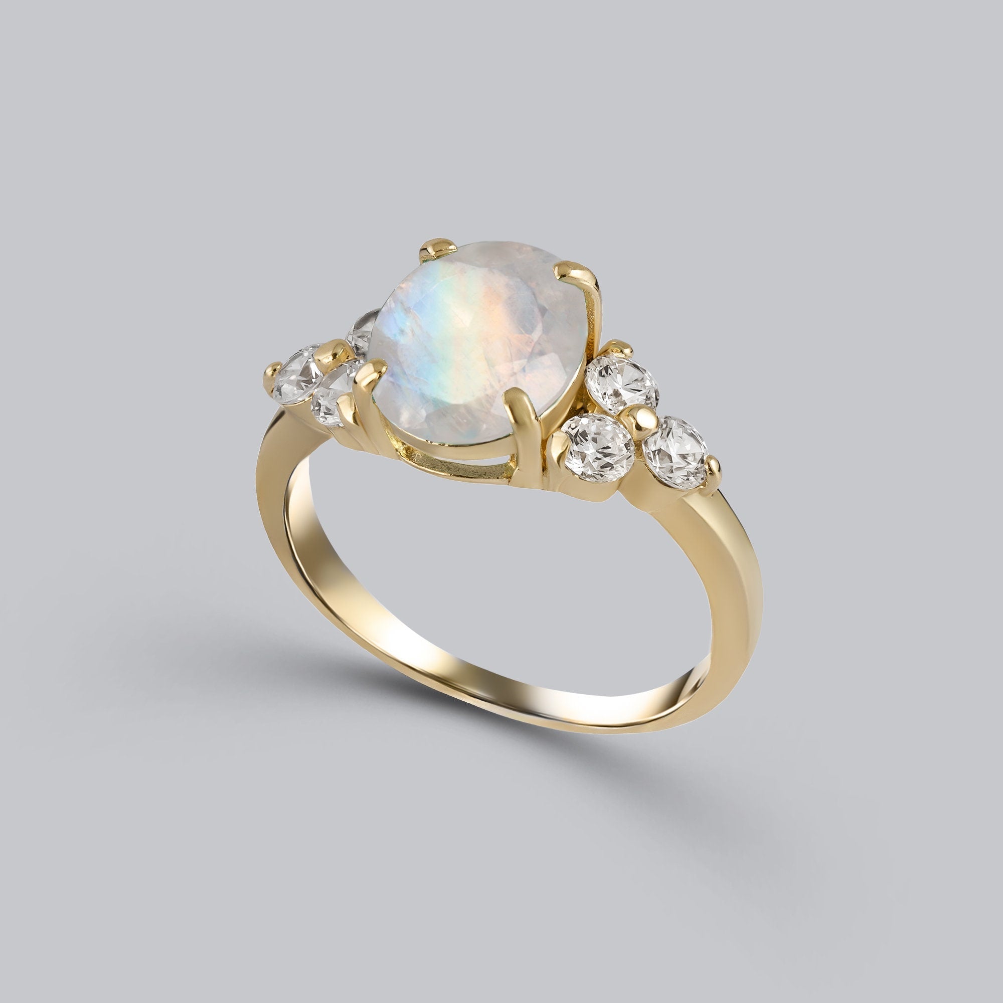 An absolute stunner, classic natural moonstone engagement ring with an oval cut gemstone of your choice as it’s centre stone and with round cut clear quartz on the band to further accentuate it.