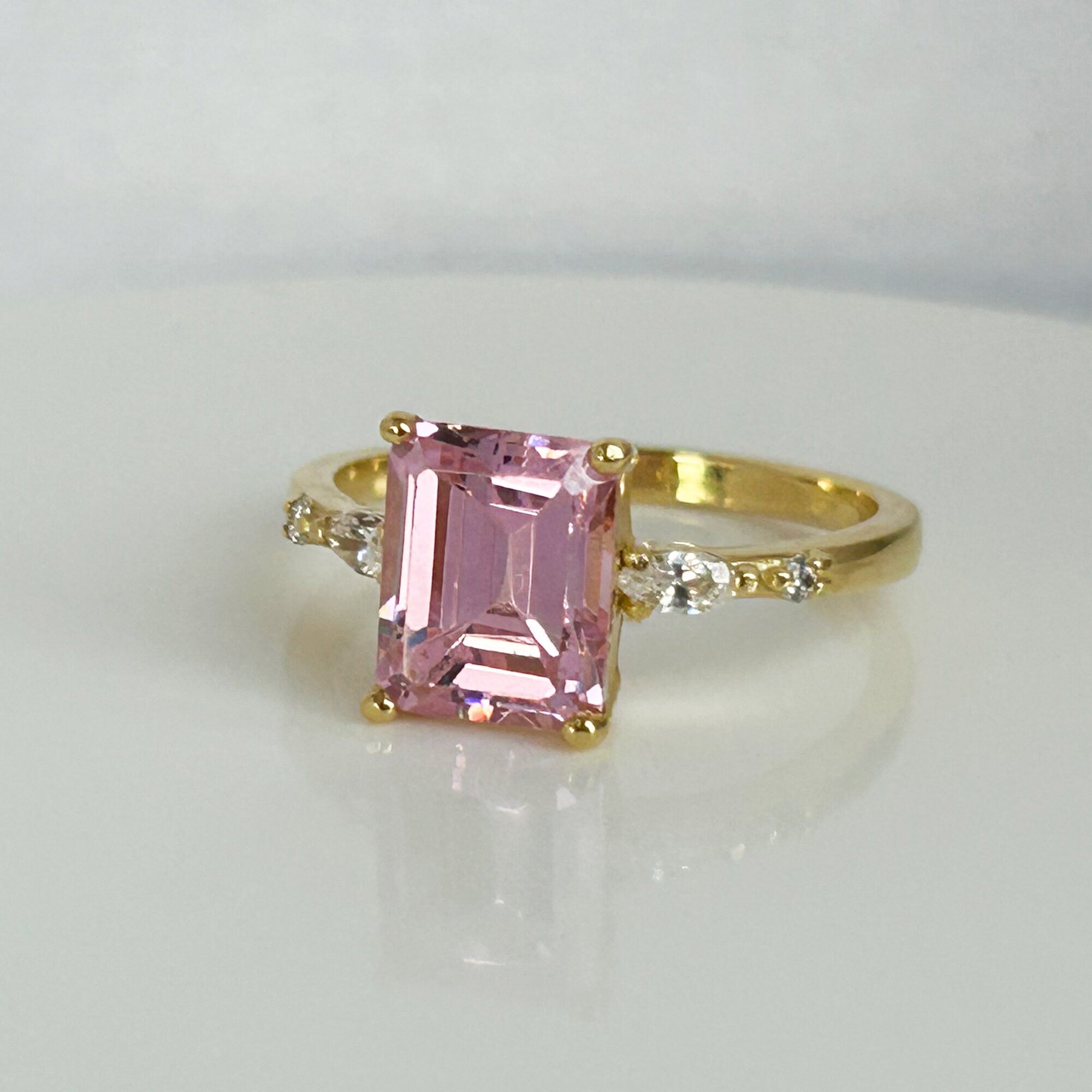 An absolute stunner, classic rose quartz engagement ring with an emerald cut gemstone of your choice as it’s centre stone and with round cut clear quartz on the band to further accentuate it.