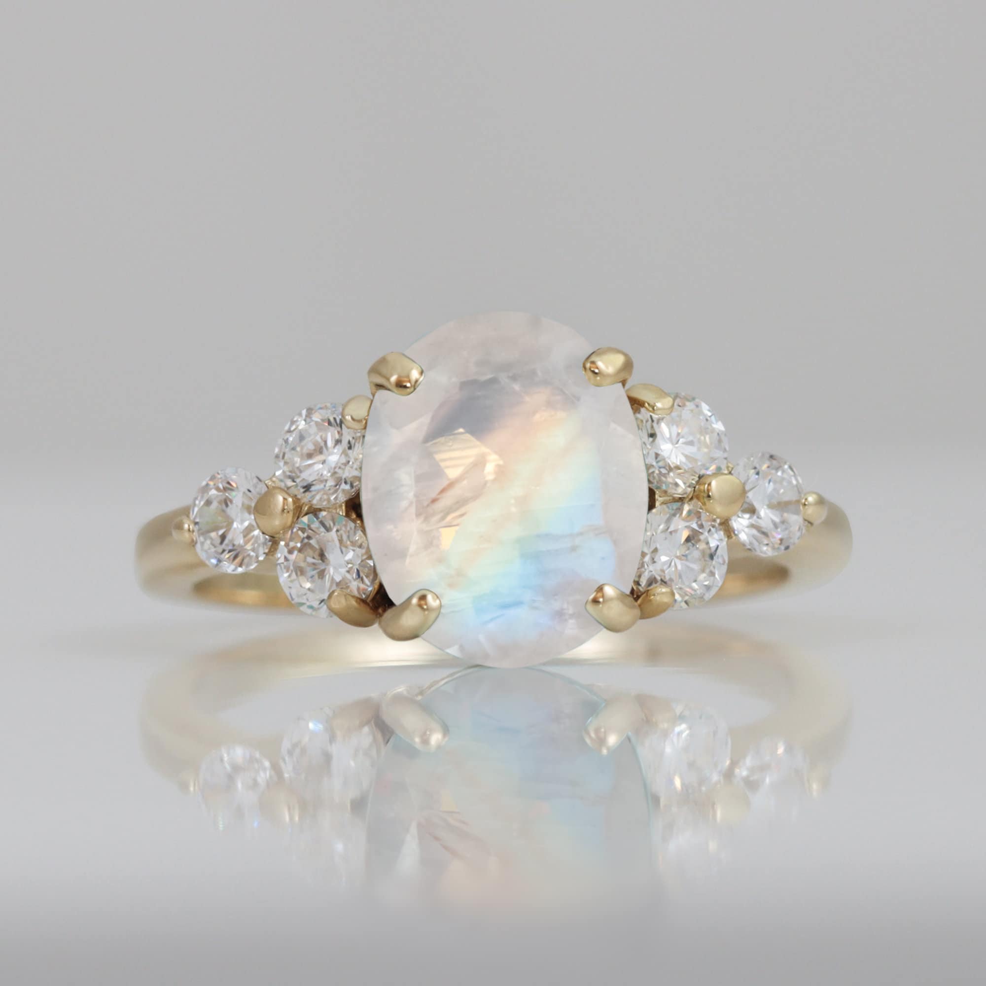 An absolute stunner, classic natural moonstone engagement ring with an oval cut gemstone of your choice as it’s centre stone and with round cut clear quartz on the band to further accentuate it.