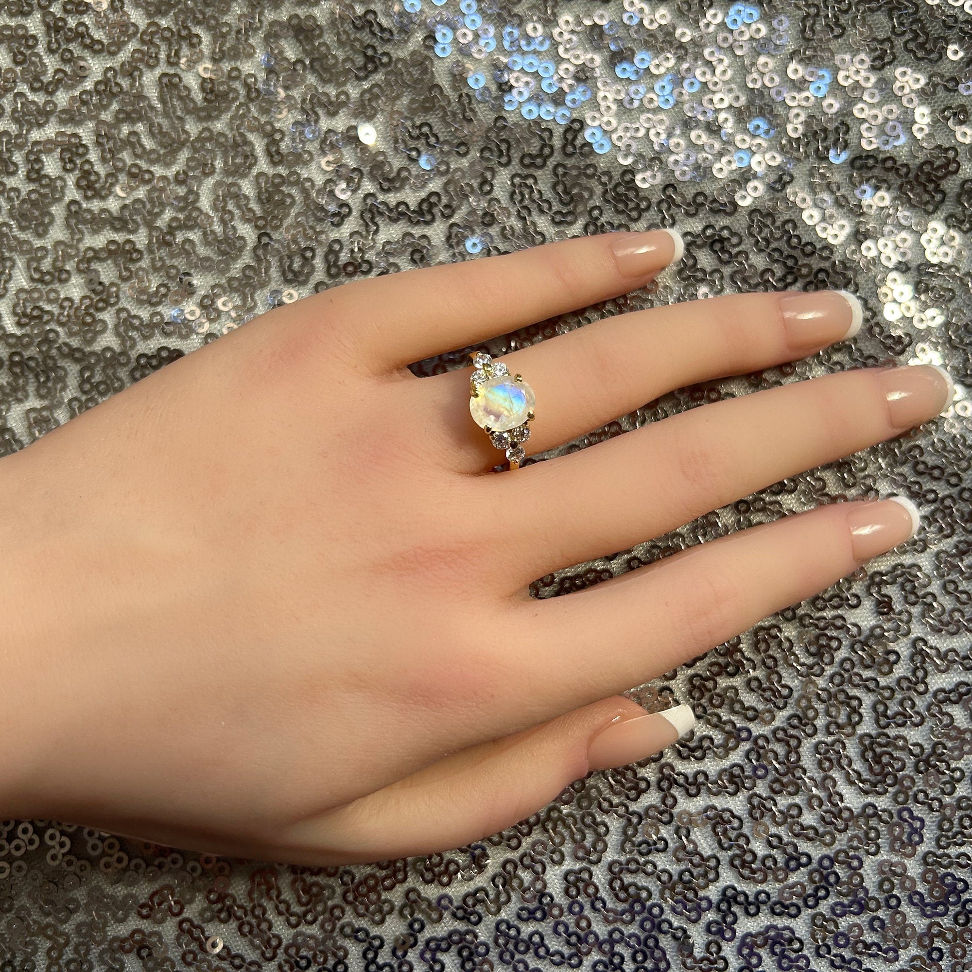 An absolute stunner, classic natural moonstone engagement ring with an oval cut gemstone of your choice as it’s centre stone and with round cut clear quartz on the band to further accentuate it.