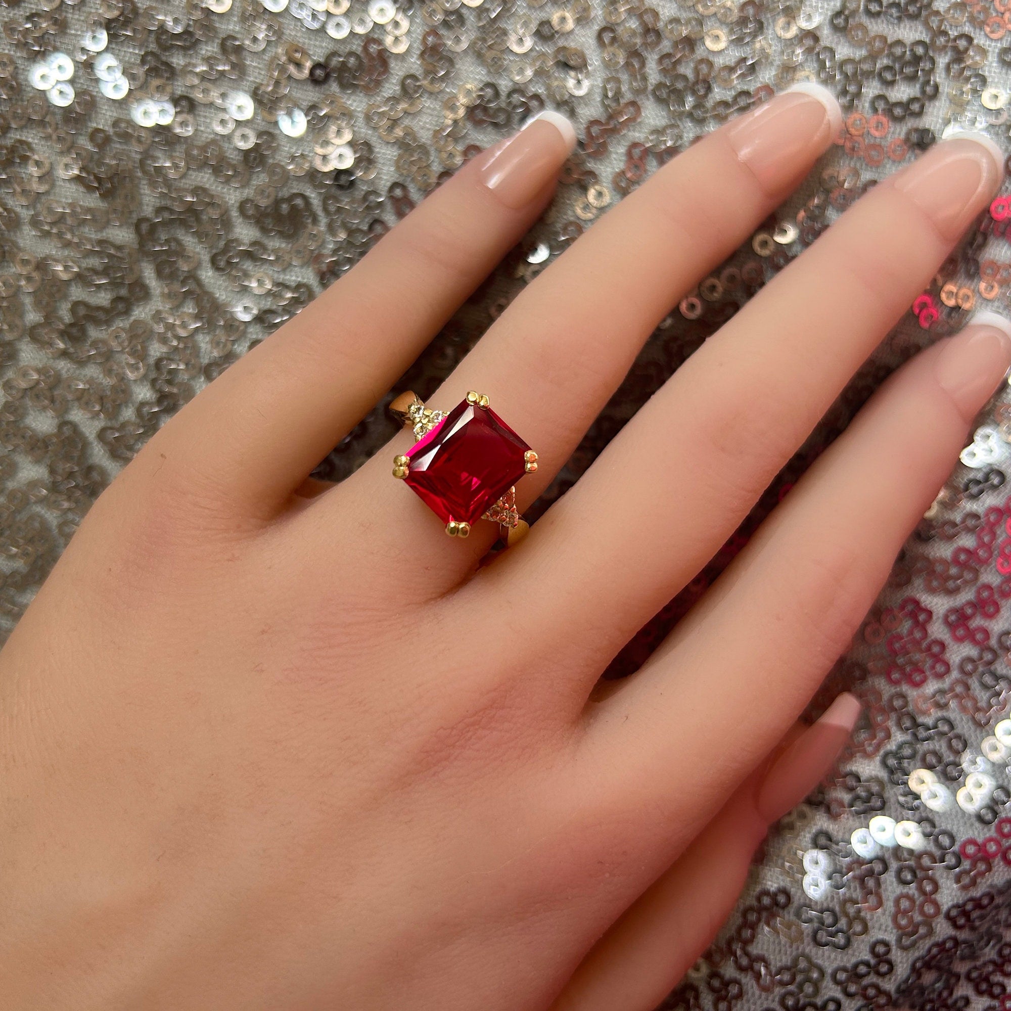 An absolute stunner, classic ruby engagement ring with an emerald cut gemstone of your choice as it’s centre stone and with round cut clear quartz on the band to further accentuate it.