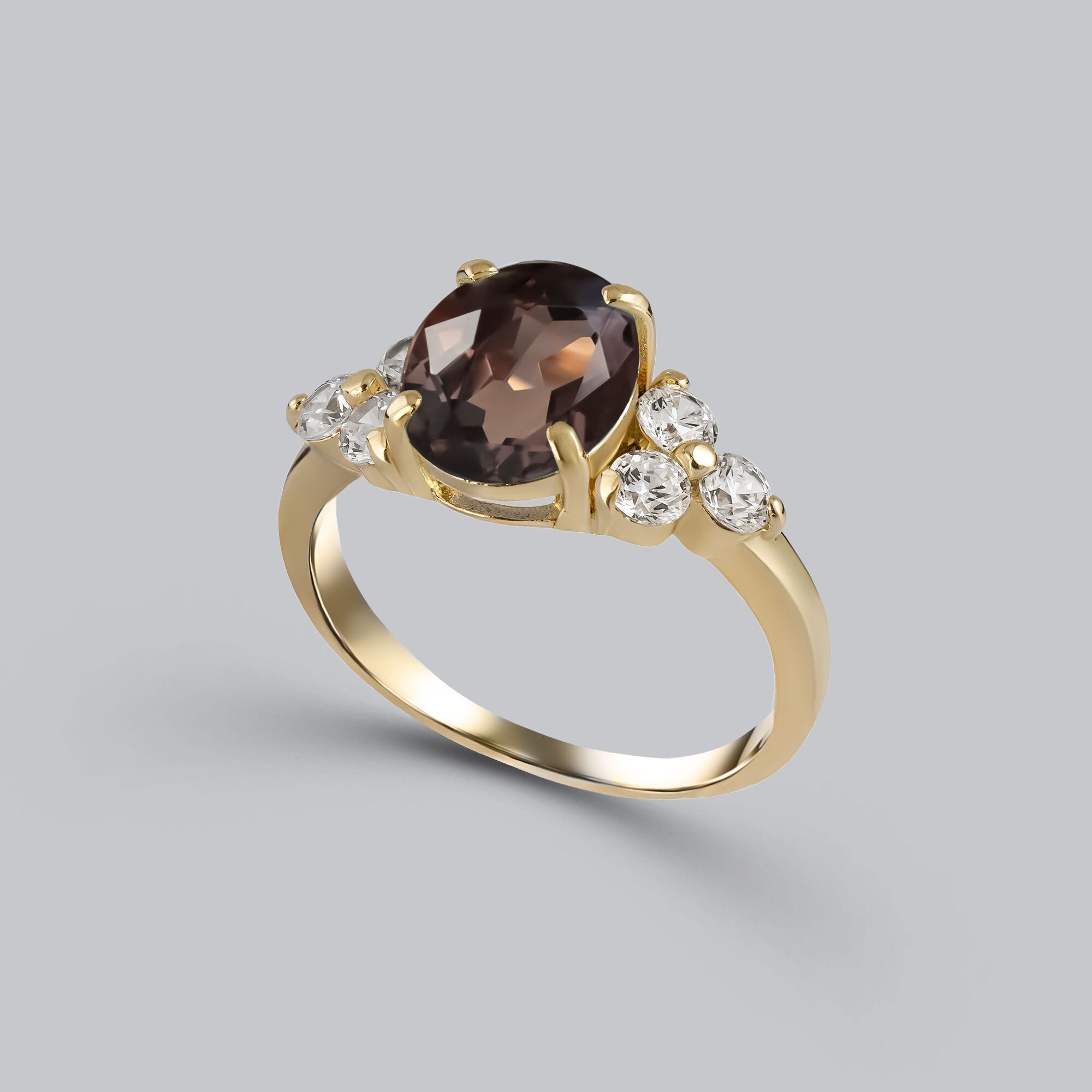 An absolute stunner, classic natural smoky quartz engagement ring with an oval cut gemstone of your choice as it’s centre stone and with round cut clear quartz on the band to further accentuate it.