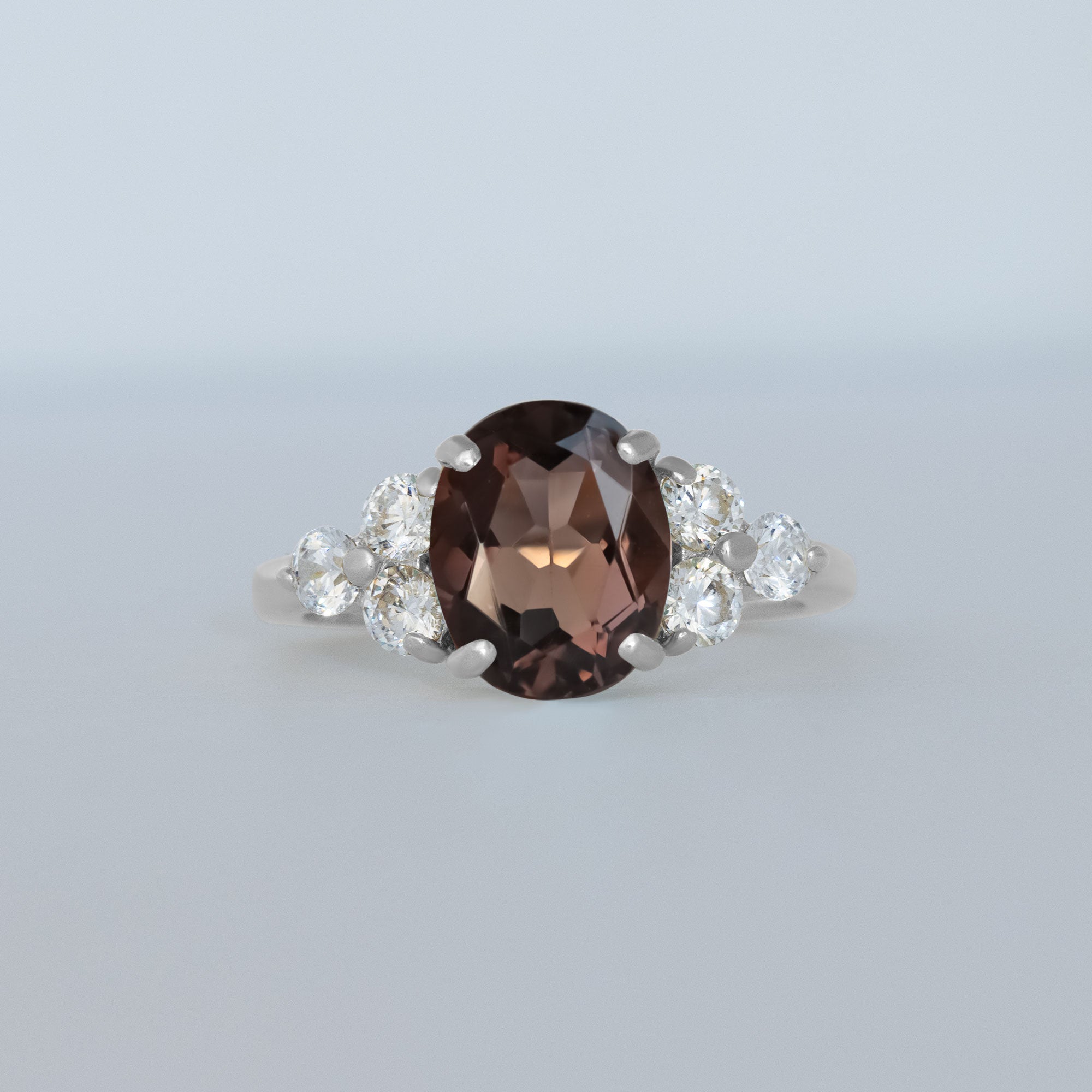 An absolute stunner, classic natural smoky quartz engagement ring with an oval cut gemstone of your choice as it’s centre stone and with round cut clear quartz on the band to further accentuate it.