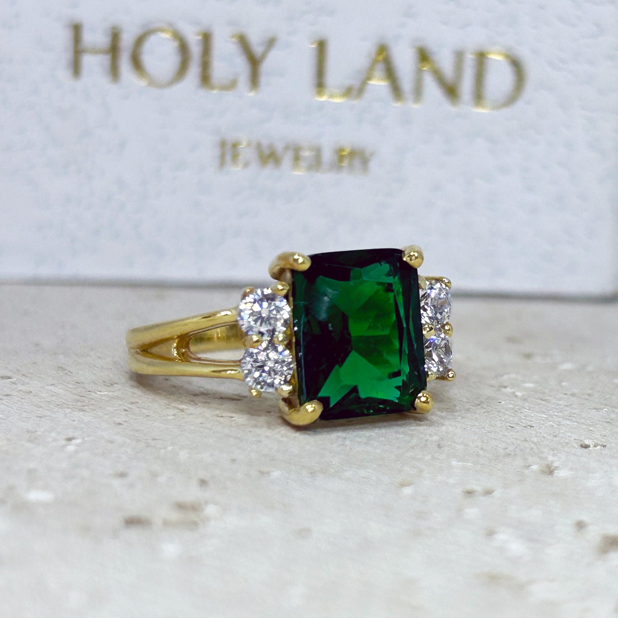 An absolute stunner, classic emerald engagement ring with an emerald cut gemstone of your choice as it’s centre stone and with round cut clear quartz on the band to further accentuate it.