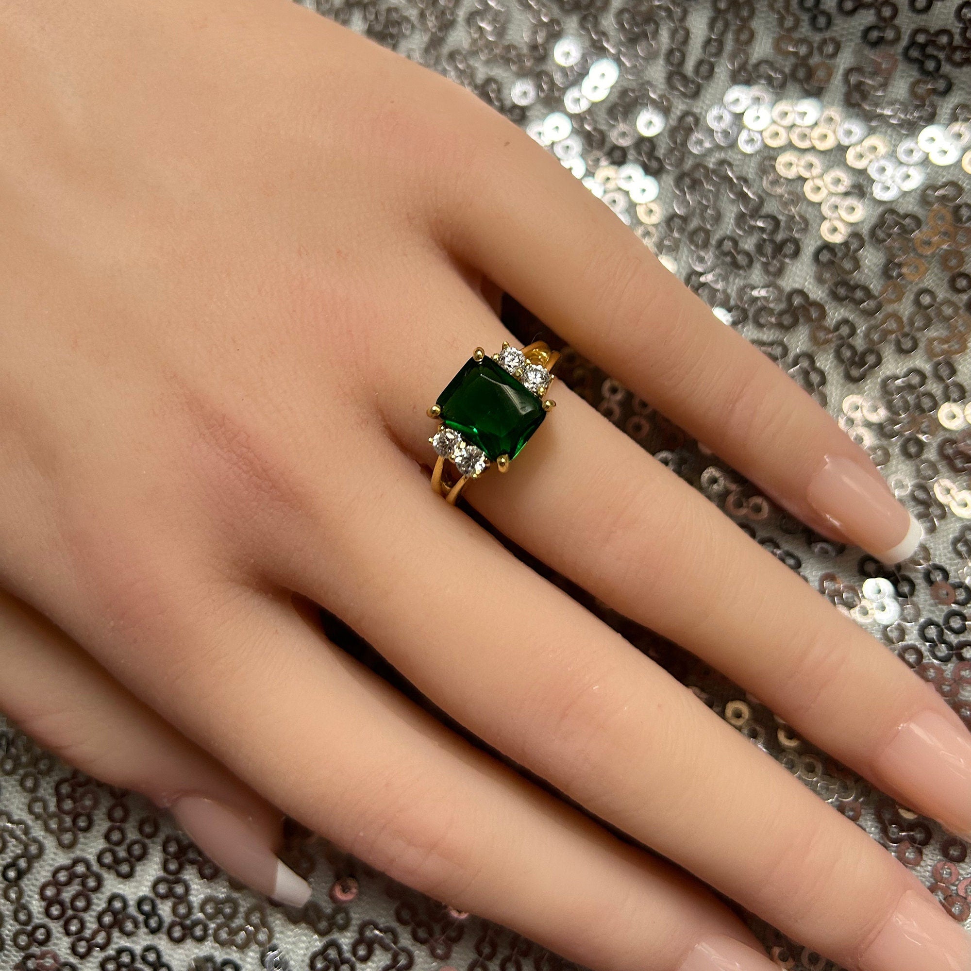 An absolute stunner, classic emerald engagement ring with an emerald cut gemstone of your choice as it’s centre stone and with round cut clear quartz on the band to further accentuate it.