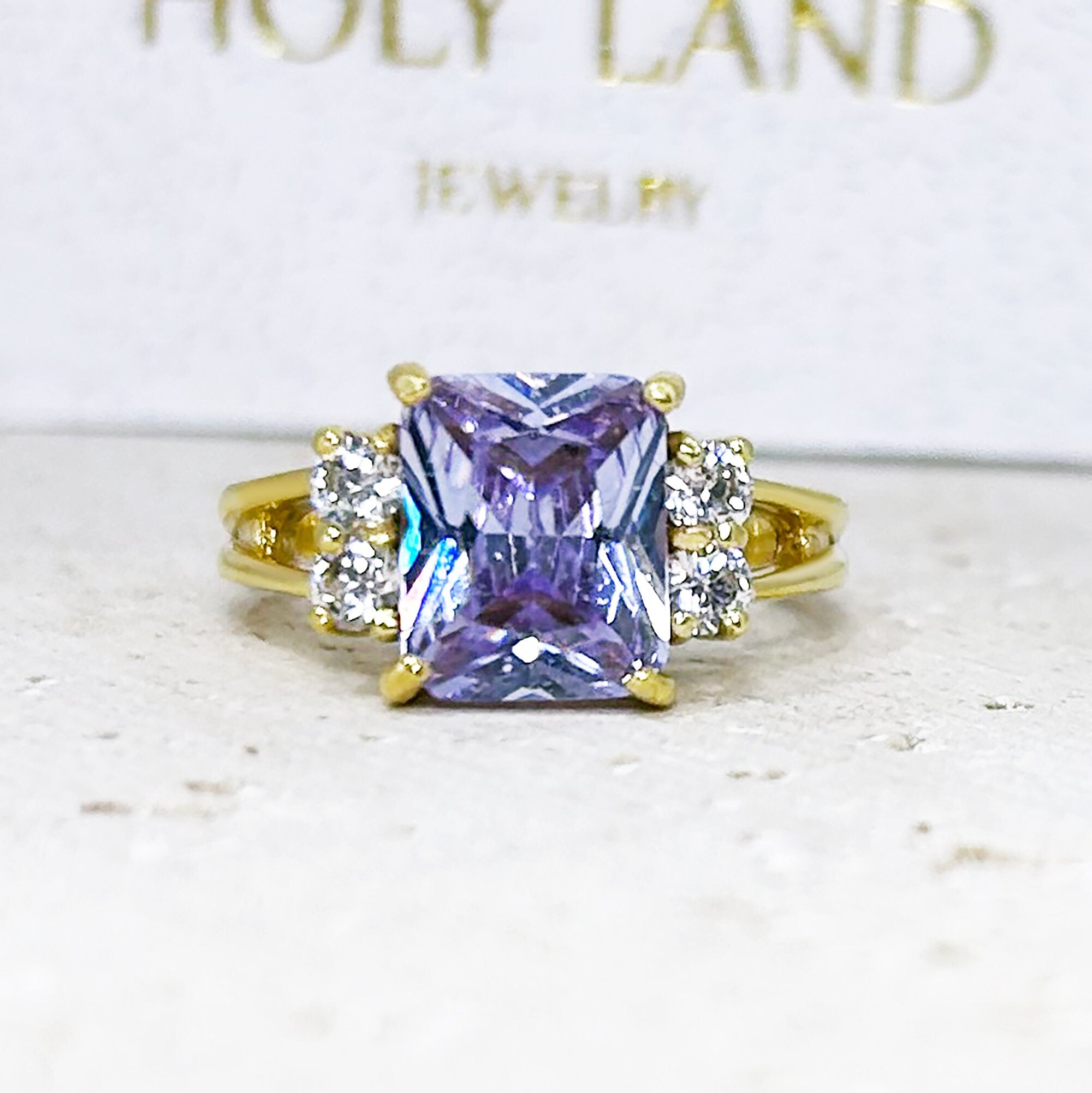 An absolute stunner, classic lavender amethyst engagement ring with an emerald cut gemstone of your choice as it’s centre stone and with round cut clear quartz on the band to further accentuate it.