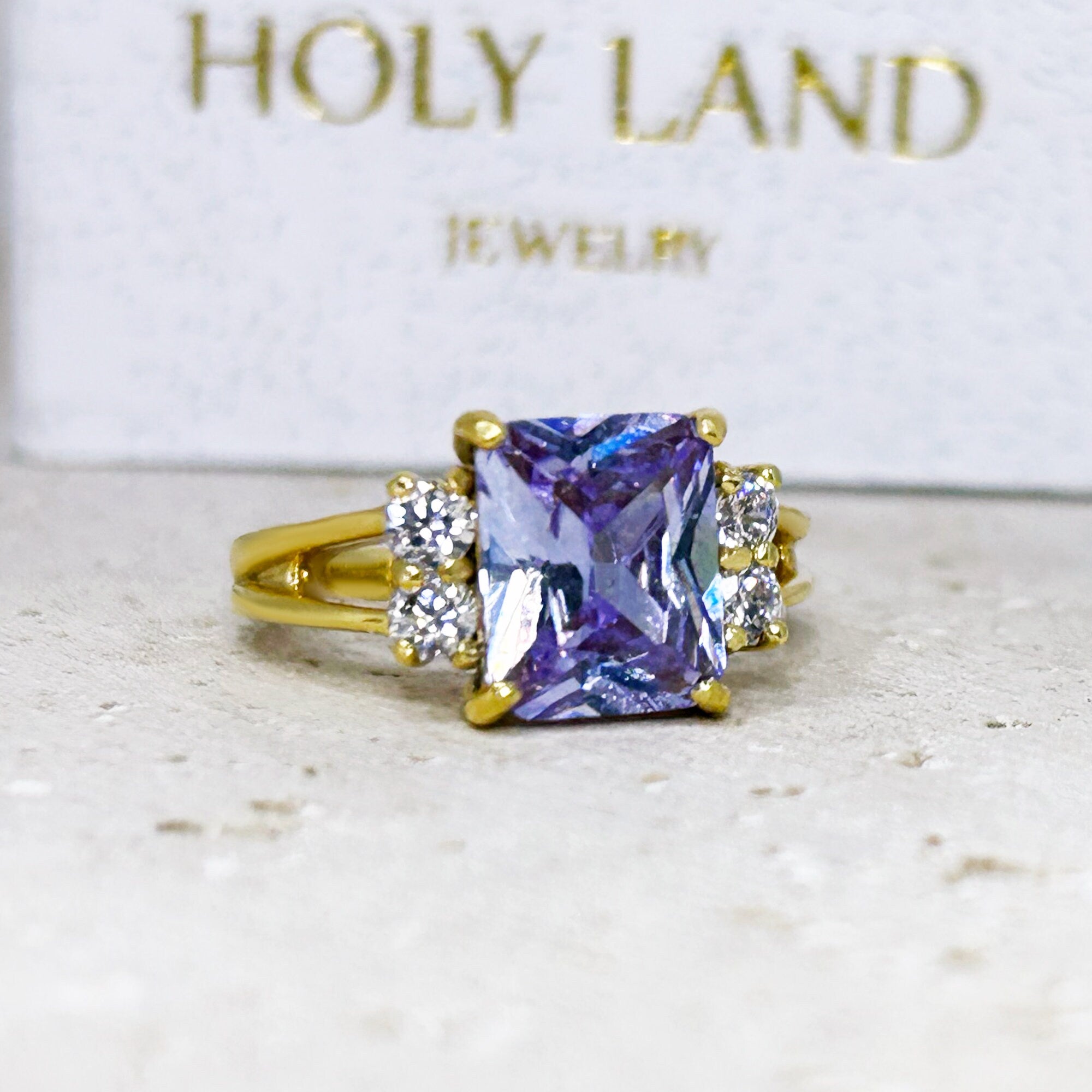 An absolute stunner, classic lavender amethyst engagement ring with an emerald cut gemstone of your choice as it’s centre stone and with round cut clear quartz on the band to further accentuate it.