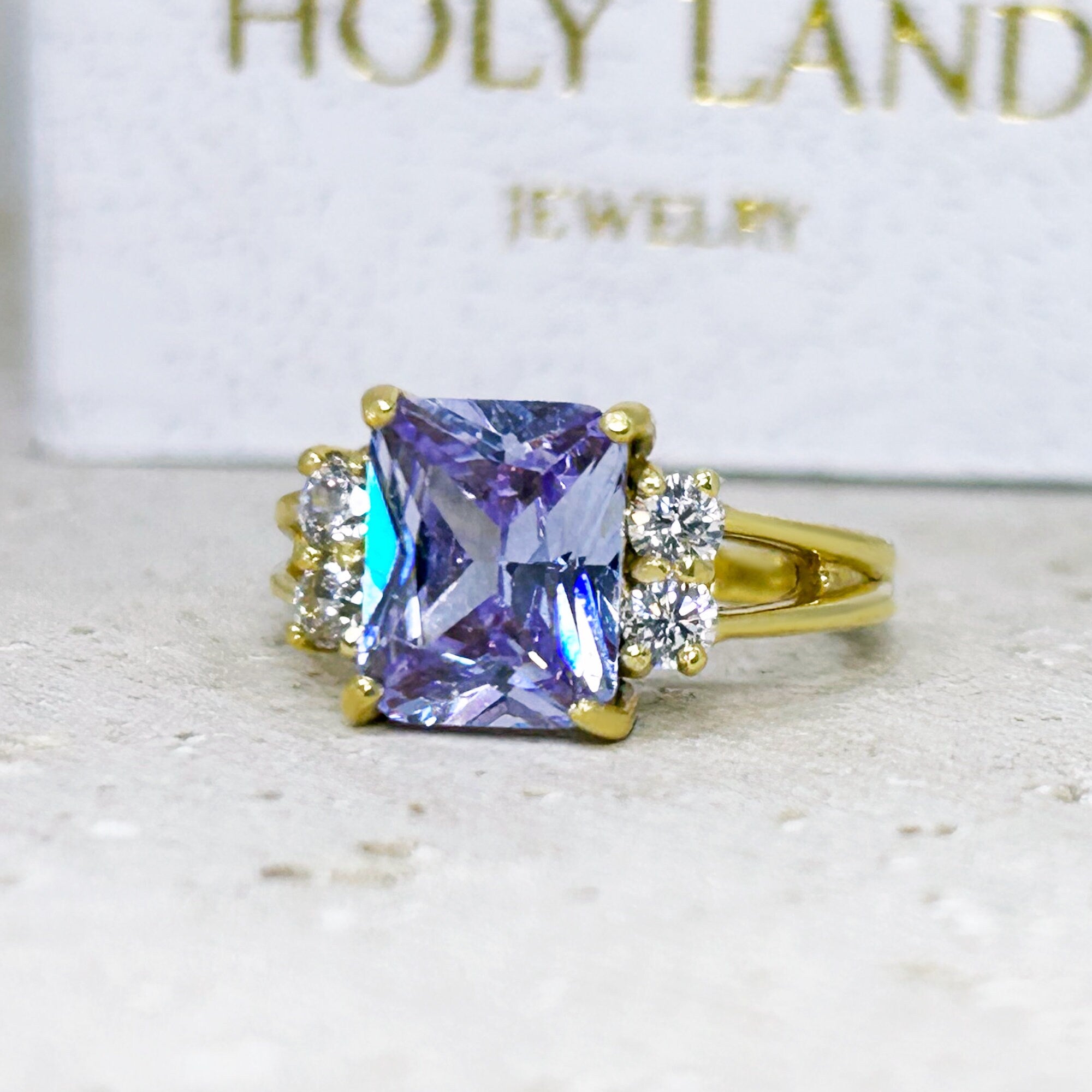 An absolute stunner, classic lavender amethyst engagement ring with an emerald cut gemstone of your choice as it’s centre stone and with round cut clear quartz on the band to further accentuate it.