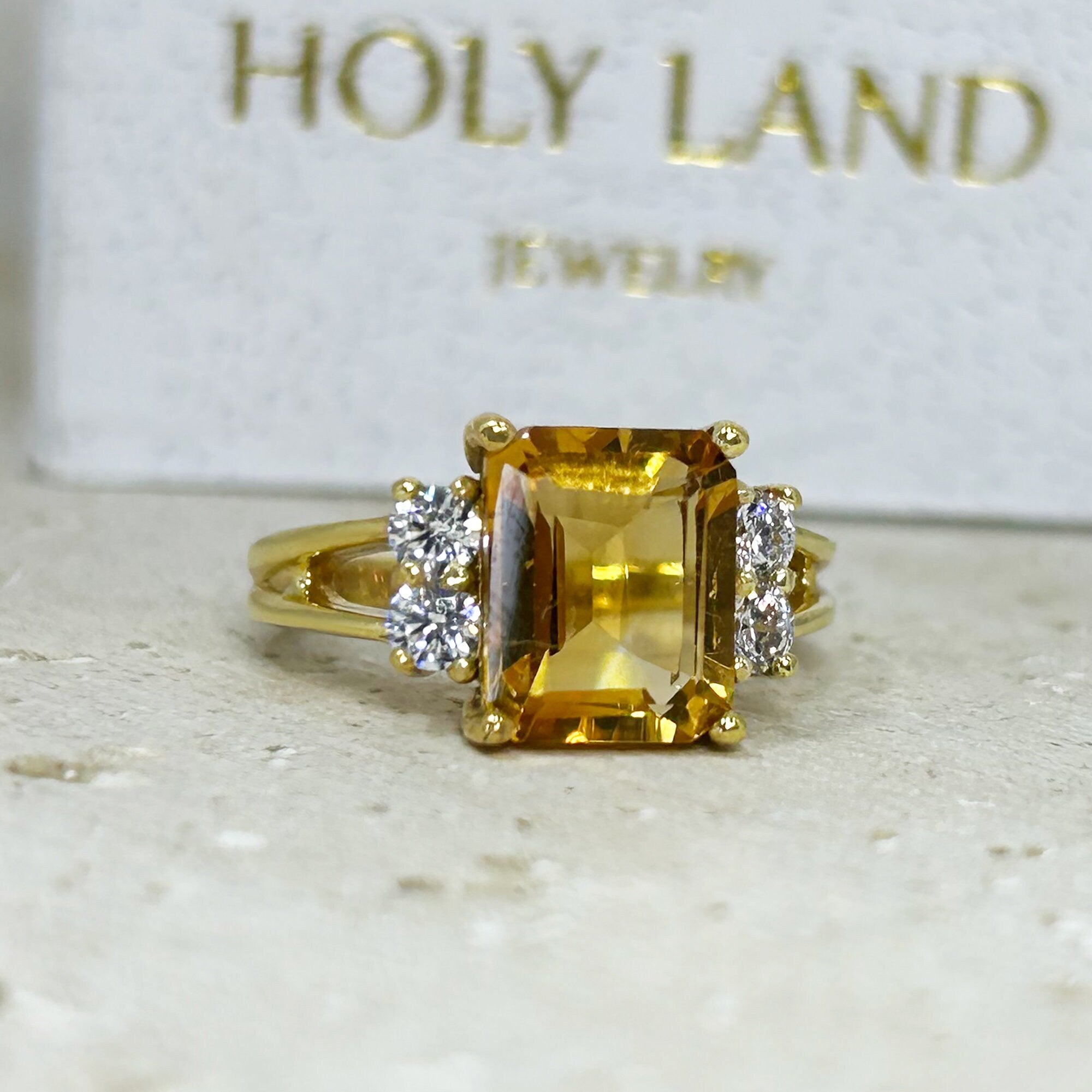 An absolute stunner, classic natural Citrine engagement ring with an emerald cut gemstone of your choice as it’s centre stone and with round cut clear quartz on the band to further accentuate it.