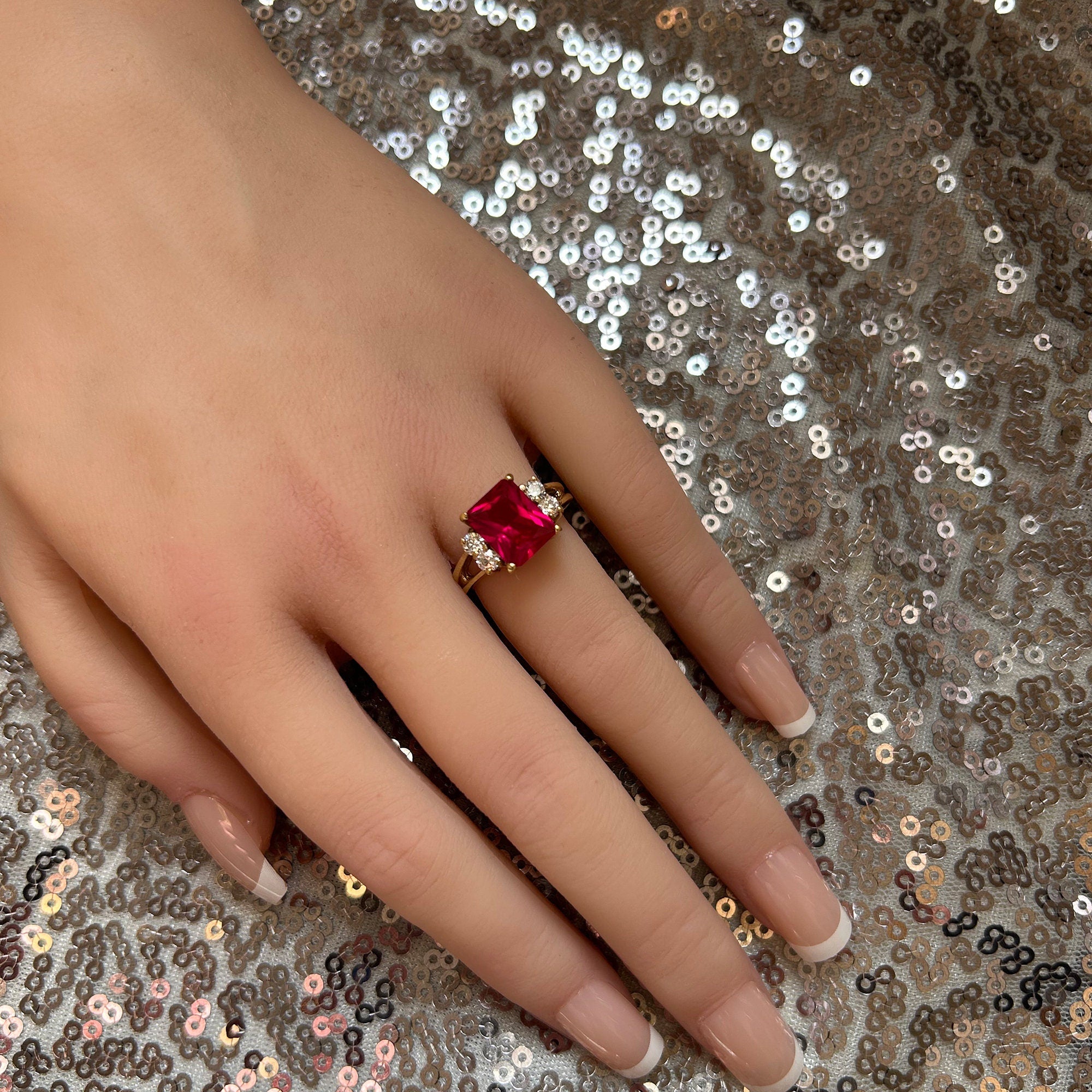 An absolute stunner, classic ruby engagement ring with an emerald cut gemstone of your choice as it’s centre stone and with round cut clear quartz on the band to further accentuate it.