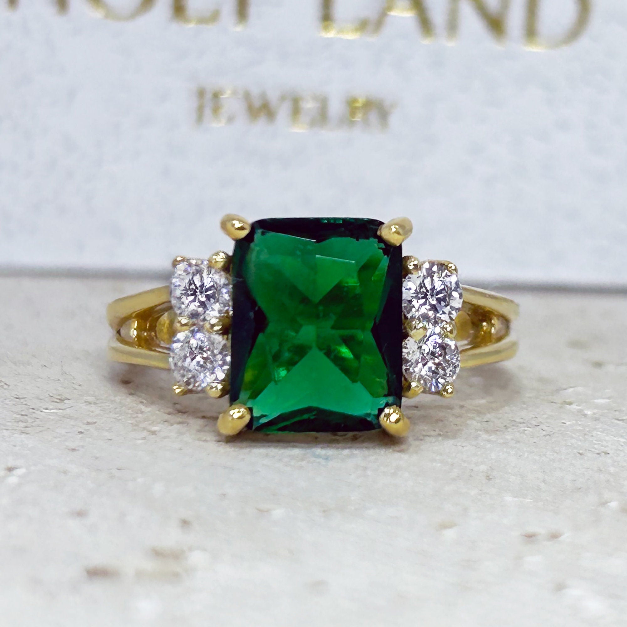 An absolute stunner, classic emerald engagement ring with an emerald cut gemstone of your choice as it’s centre stone and with round cut clear quartz on the band to further accentuate it.