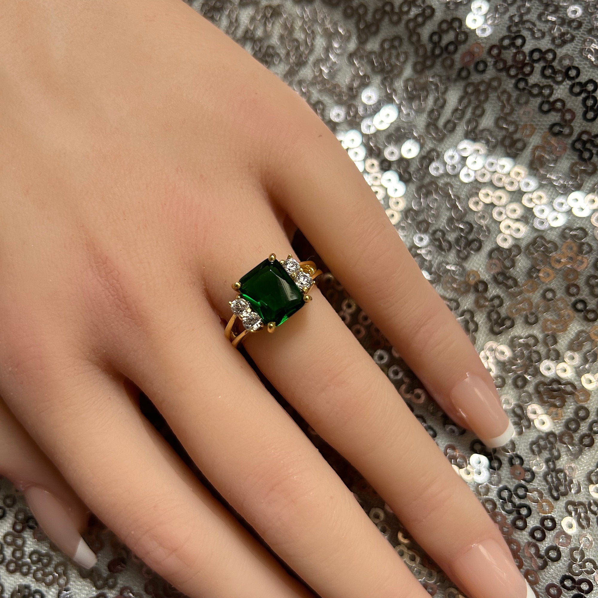 An absolute stunner, classic emerald engagement ring with an emerald cut gemstone of your choice as it’s centre stone and with round cut clear quartz on the band to further accentuate it.