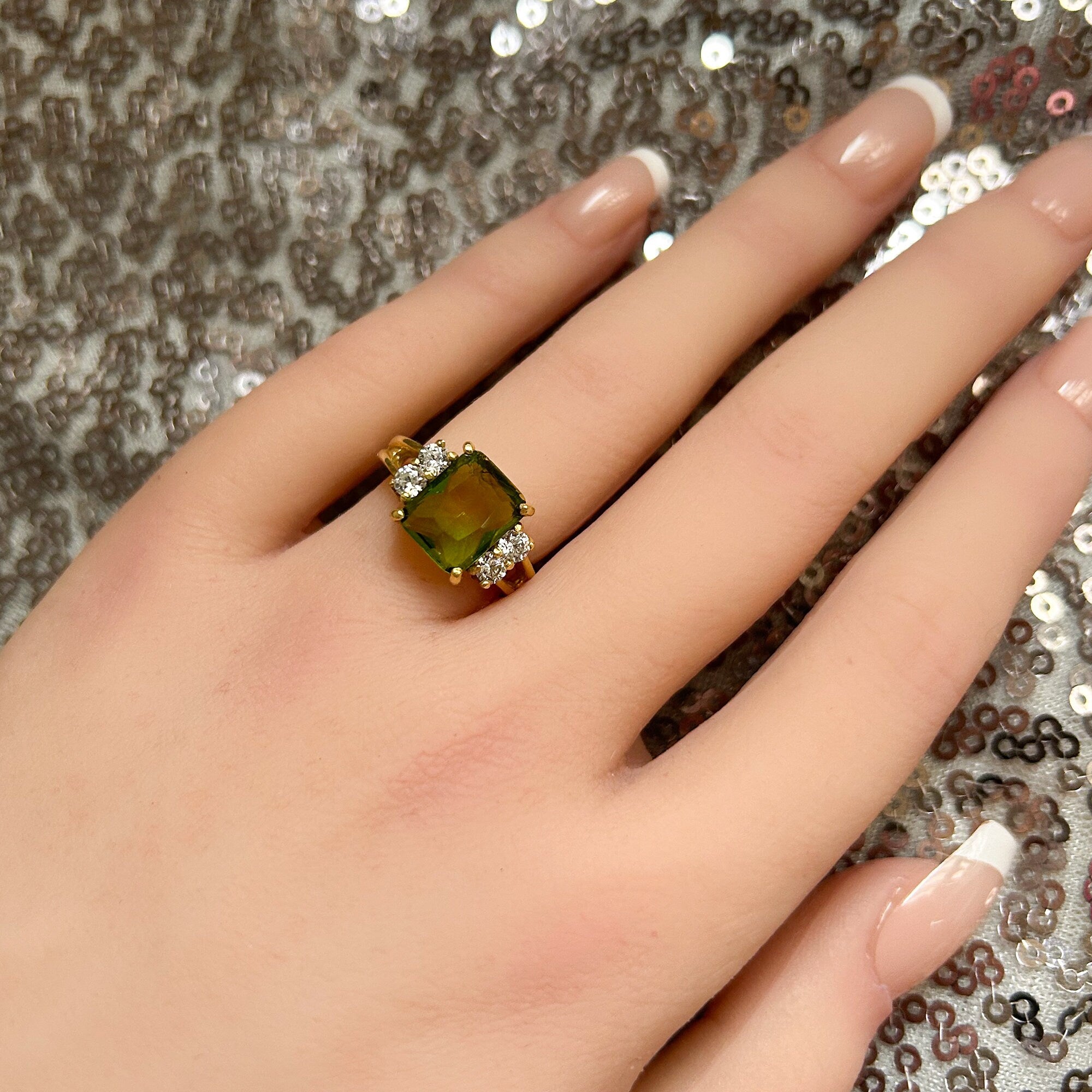 An absolute stunner, classic peridot engagement ring with an emerald cut gemstone of your choice as it’s centre stone and with round cut clear quartz on the band to further accentuate it.