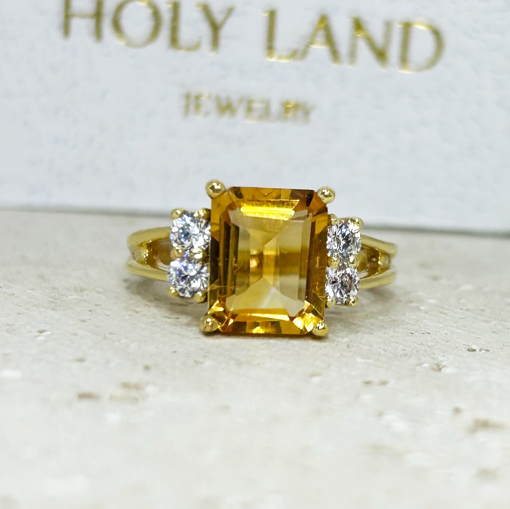 An absolute stunner, classic natural Citrine engagement ring with an emerald cut gemstone of your choice as it’s centre stone and with round cut clear quartz on the band to further accentuate it.