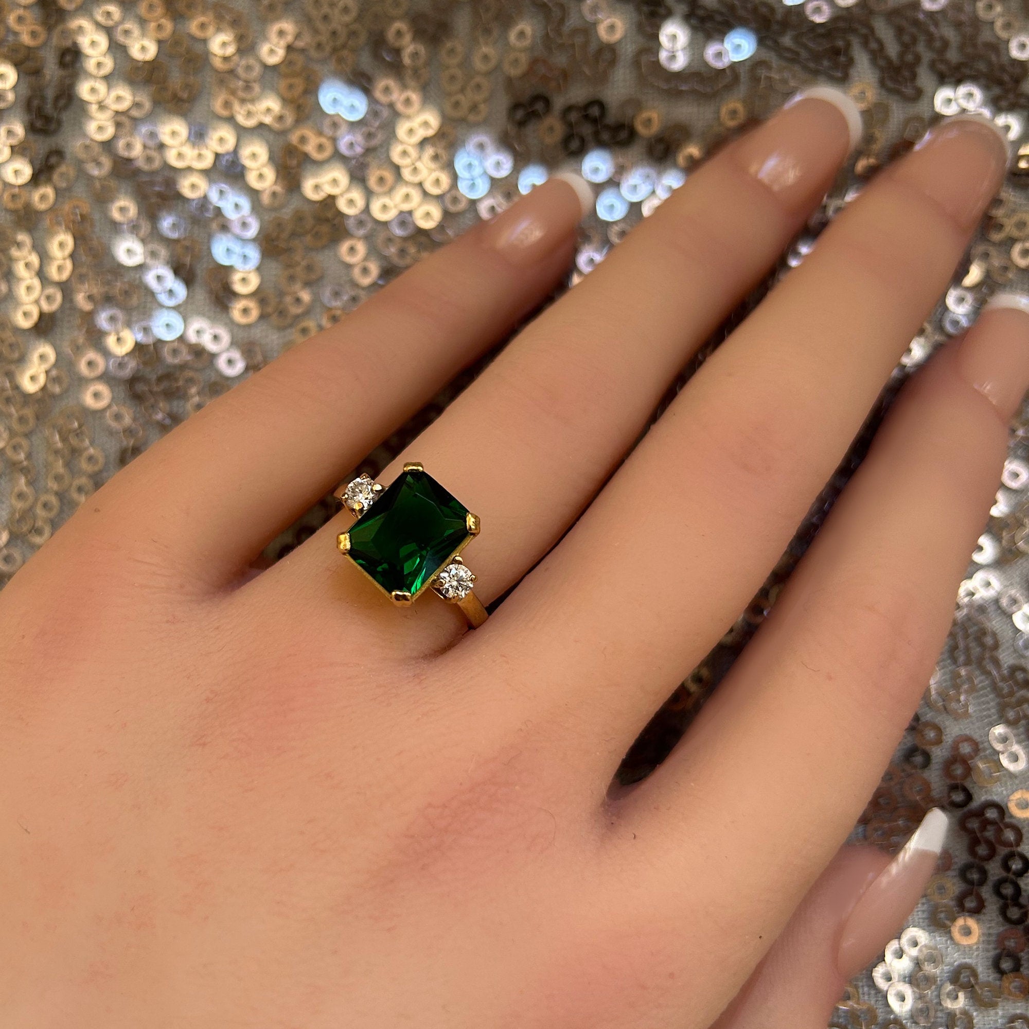 An absolute stunner, classic emerald engagement ring with an emerald cut gemstone of your choice as it’s centre stone and with round cut clear quartz on the band to further accentuate it.