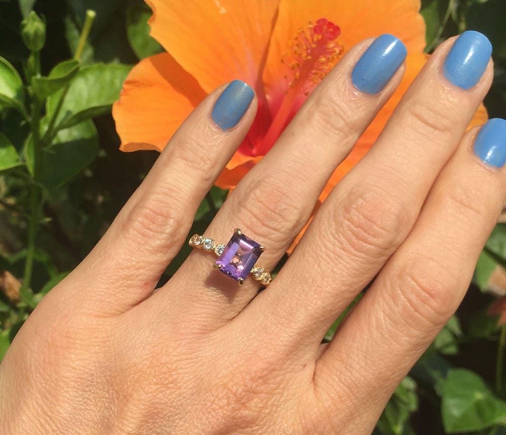 An absolute stunner, classic natural amethyst engagement ring with an emerald cut gemstone of your choice as it’s centre stone and with round cut clear quartz on the band to further accentuate it.Purple Amethyst Ring - February Birthstone - Octagon Purple Amethyst Gemstone Statement Engagement Ring with Clear Quartz Accents