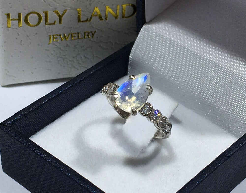 An absolute stunner, classic natural moonstone engagement ring with a pear cut gemstone of your choice as it’s centre stone and with round cut clear quartz on the band to further accentuate it.