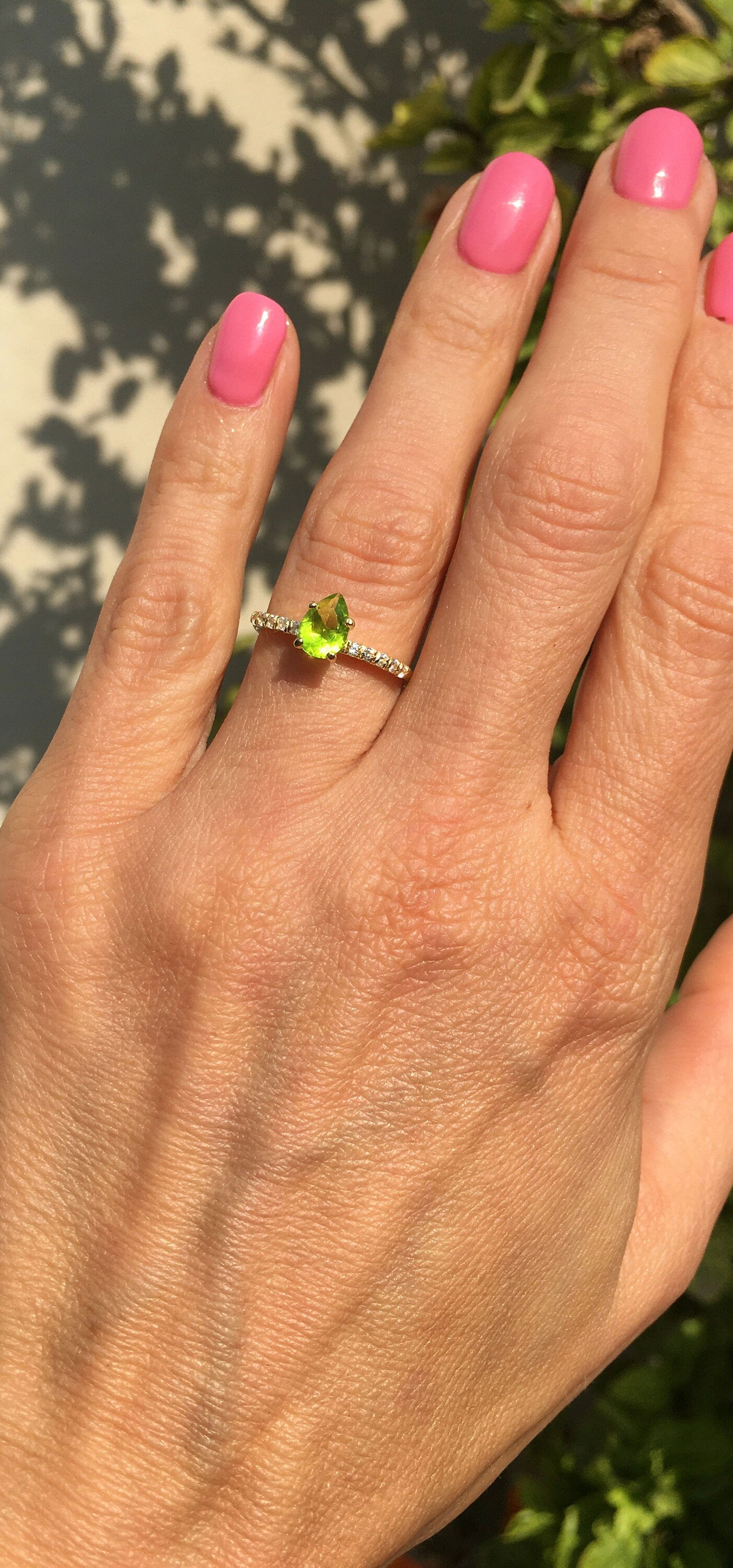 An absolute stunner, classic natural peridot engagement ring with a pear cut gemstone of your choice as it’s centre stone and with round cut clear quartz on the band to further accentuate it.