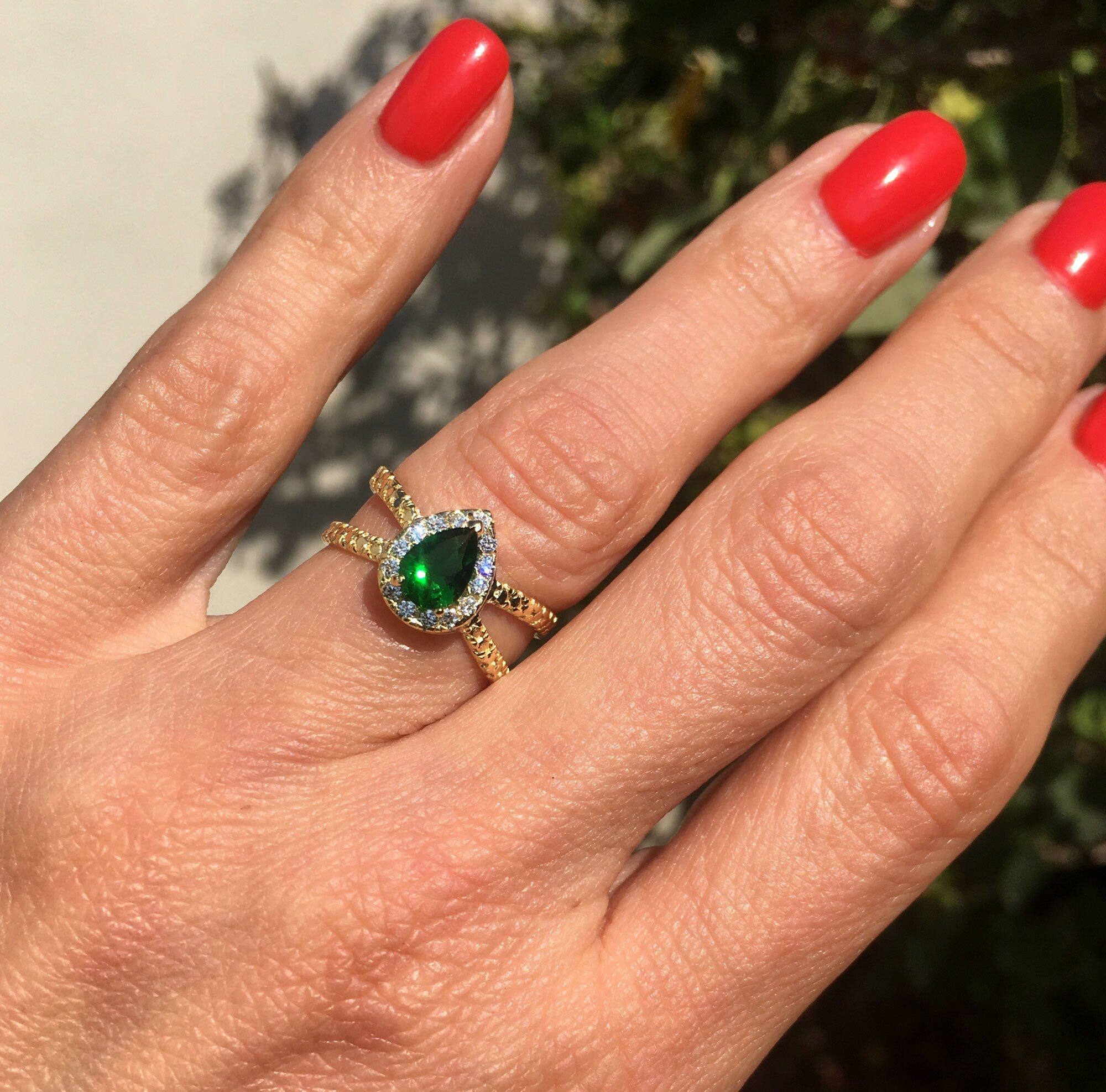 The spectacular design of this emerald ring is a contemporary take on a classic choice which will be much loved by anyone who loves bright and bold jewelry. The pear cut emerald is flanked on every side by high quality clear quartz gemstones.