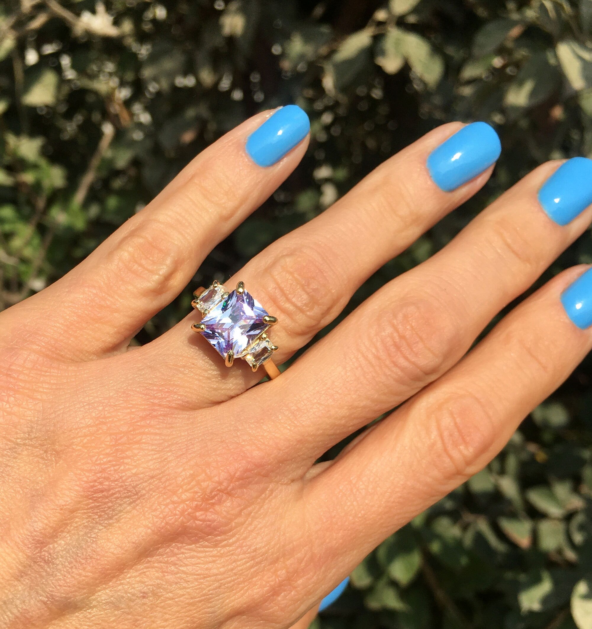 An absolute stunner, classic lavender amethyst engagement ring with a emerald cut gemstone of your choice as it’s centre stone and with round cut clear quartz on the band to further accentuate it.