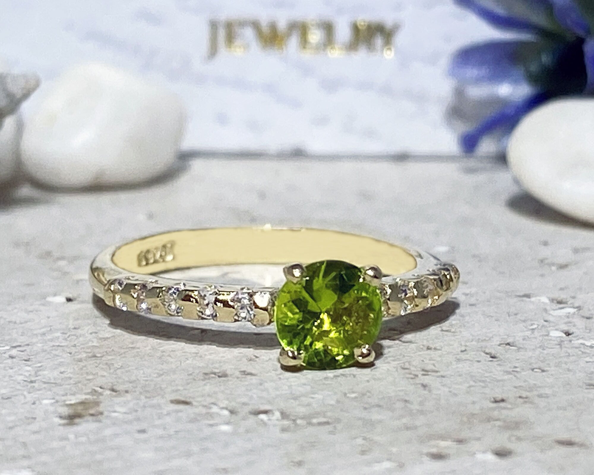 An absolute stunner, classic peridot engagement ring with a round cut gemstone of your choice as it’s centre stone and with round cut clear quartz on the band to further accentuate it.