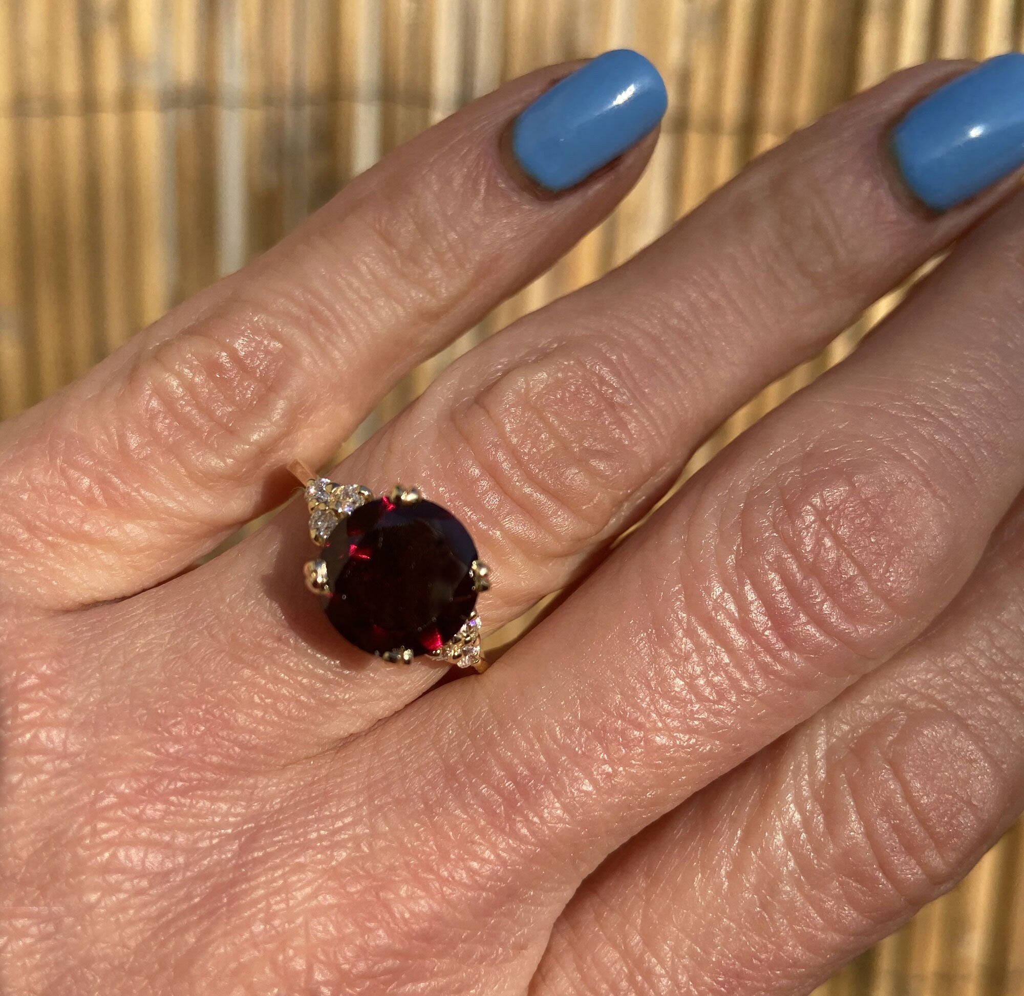 An absolute stunner, classic natural red garnet engagement ring with a round cut gemstone of your choice as it’s centre stone and with round cut clear quartz on the band to further accentuate it.