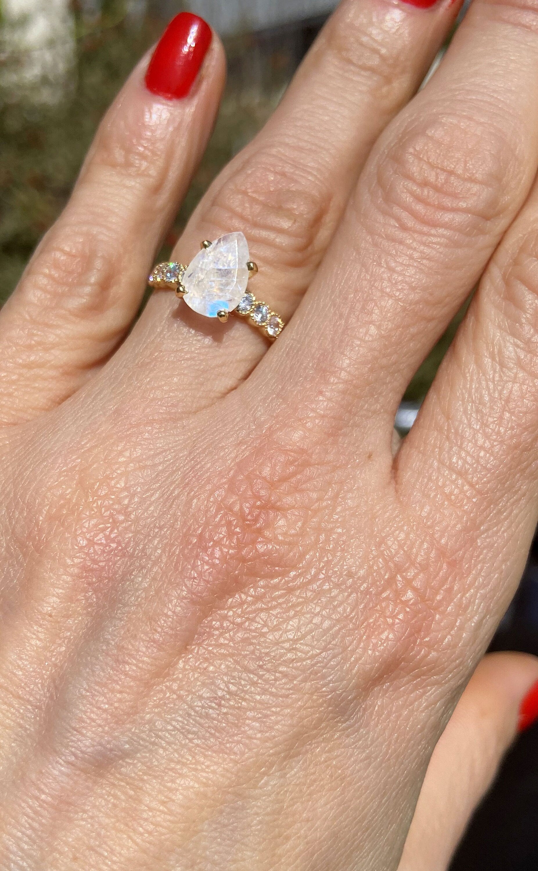 An absolute stunner, classic natural moonstone engagement ring with a pear cut gemstone of your choice as it’s centre stone and with round cut clear quartz on the band to further accentuate it.