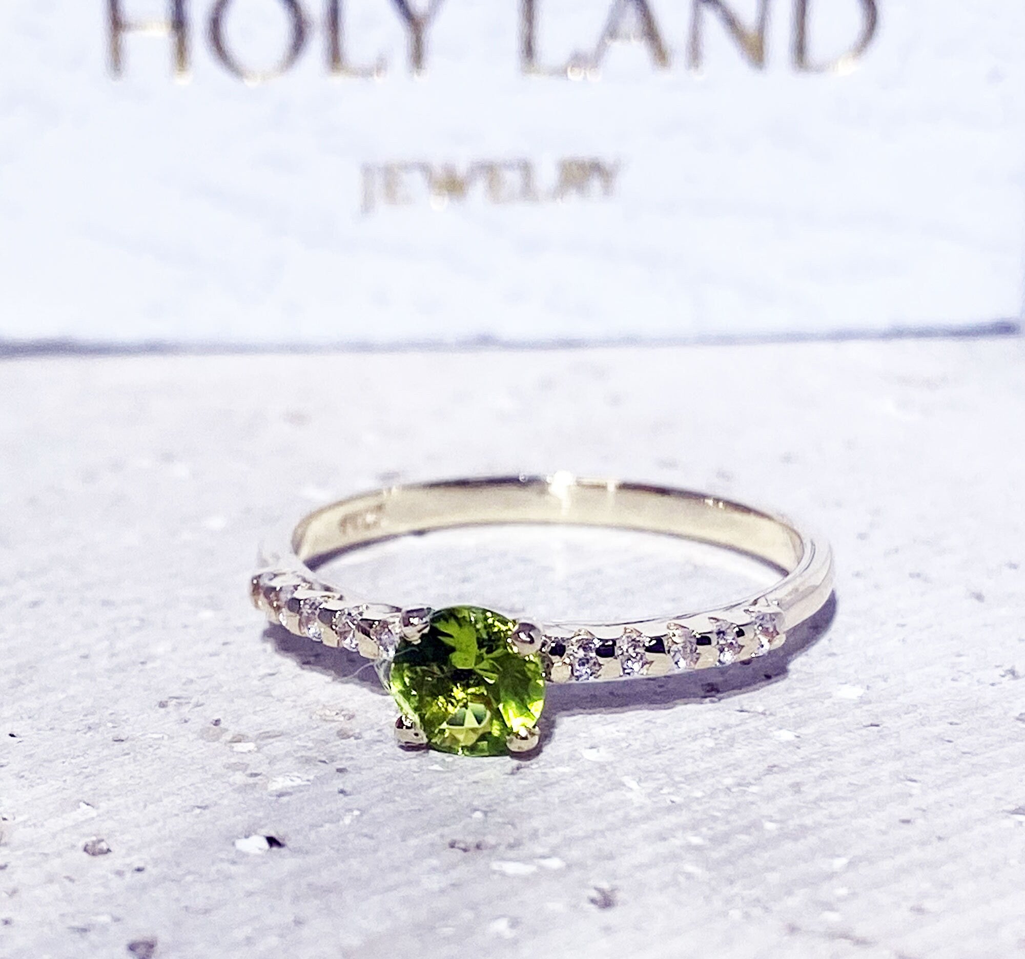 An absolute stunner, classic peridot engagement ring with a round cut gemstone of your choice as it’s centre stone and with round cut clear quartz on the band to further accentuate it.