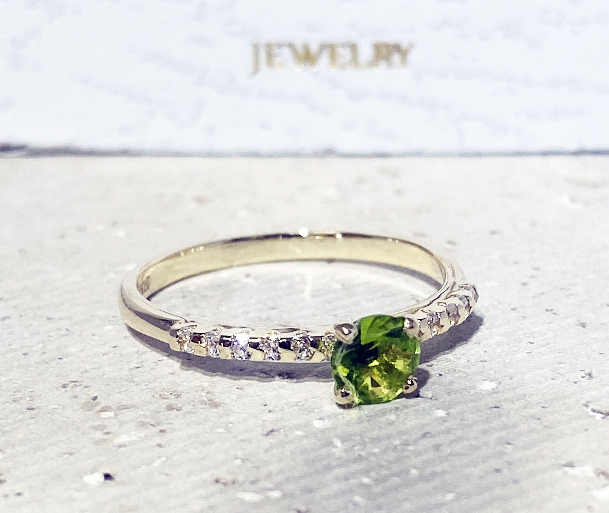 An absolute stunner, classic peridot engagement ring with a round cut gemstone of your choice as it’s centre stone and with round cut clear quartz on the band to further accentuate it.