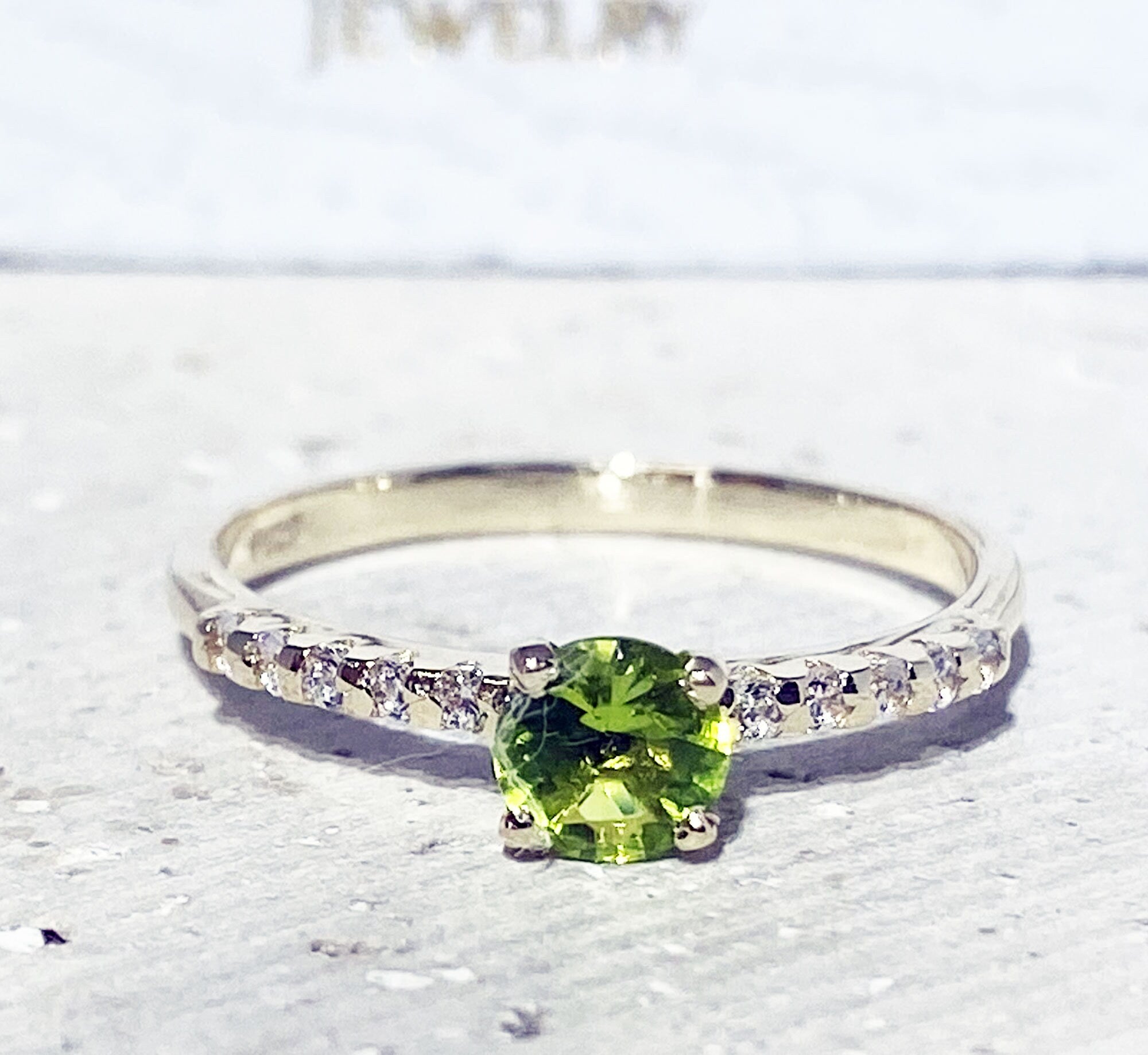 An absolute stunner, classic peridot engagement ring with a round cut gemstone of your choice as it’s centre stone and with round cut clear quartz on the band to further accentuate it.