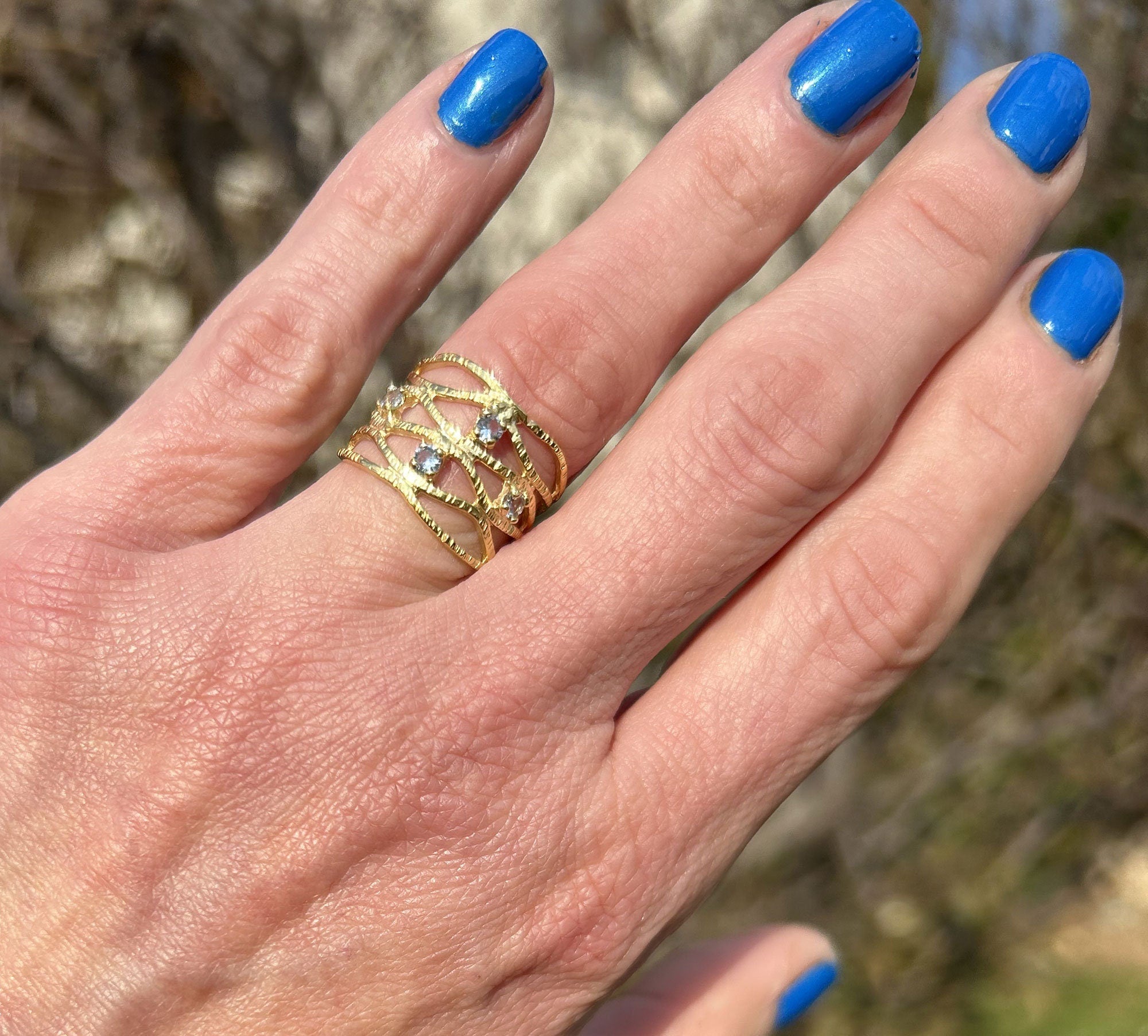 This gorgeous aquamarine ring displays simple elegance in its design. The ring features a round-cut blue aquamarine gemstone and finished with a hammered band.