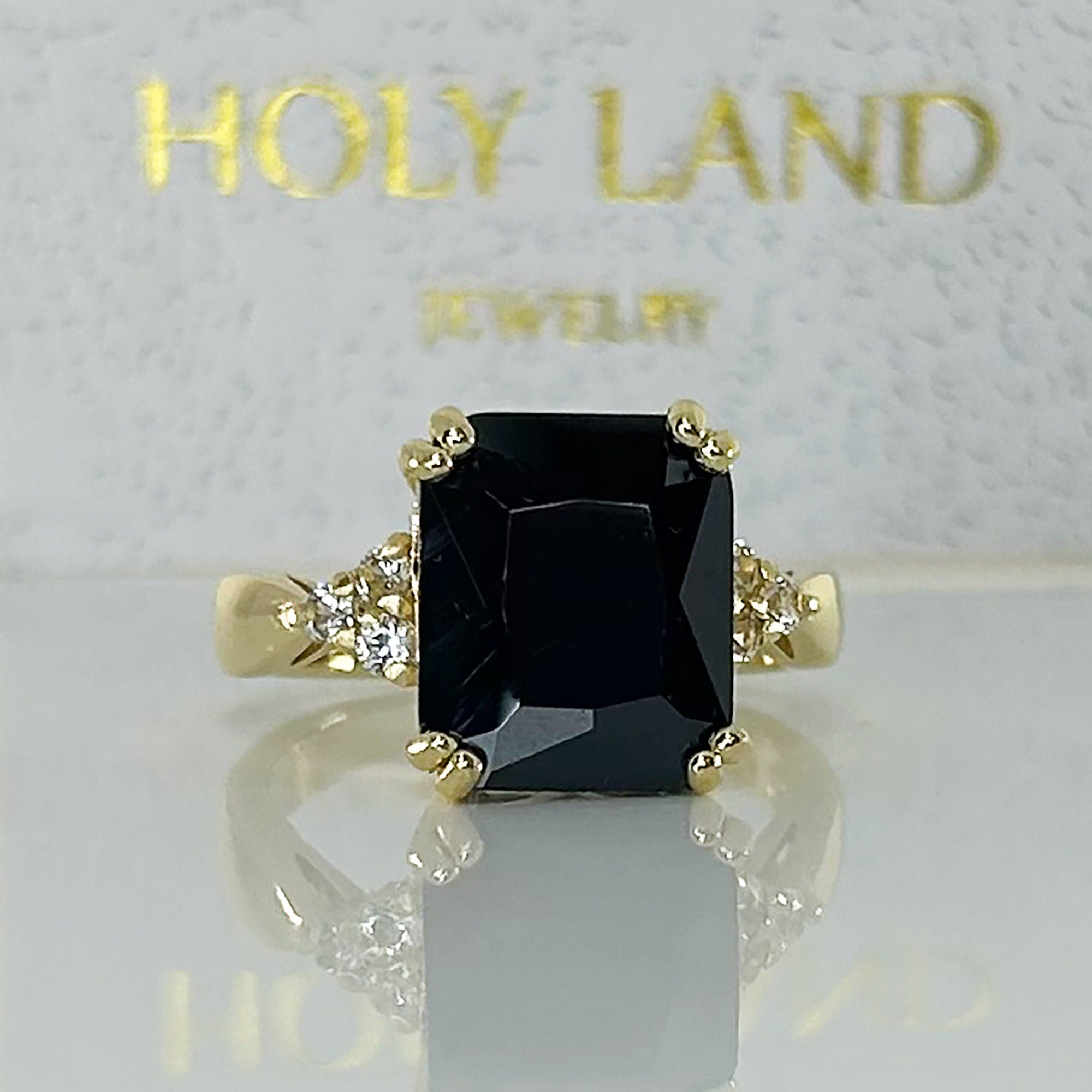 An absolute stunner, classic black onyx engagement ring with an emerald cut gemstone of your choice as it’s centre stone and with round cut clear quartz on the band to further accentuate it.