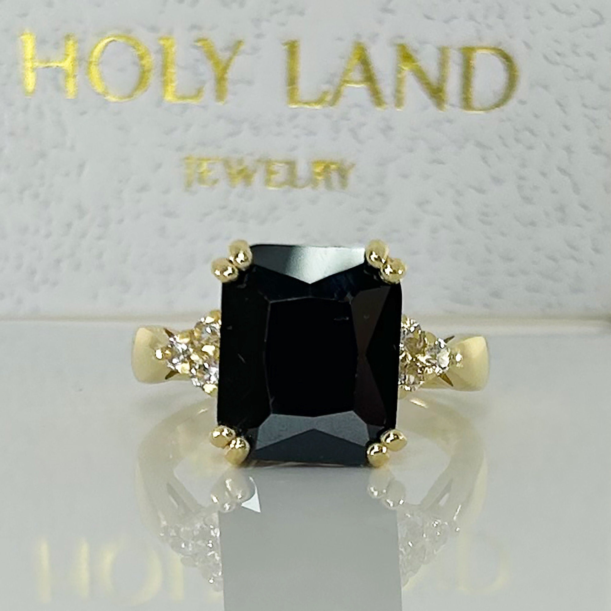 An absolute stunner, classic black onyx engagement ring with an emerald cut gemstone of your choice as it’s centre stone and with round cut clear quartz on the band to further accentuate it.