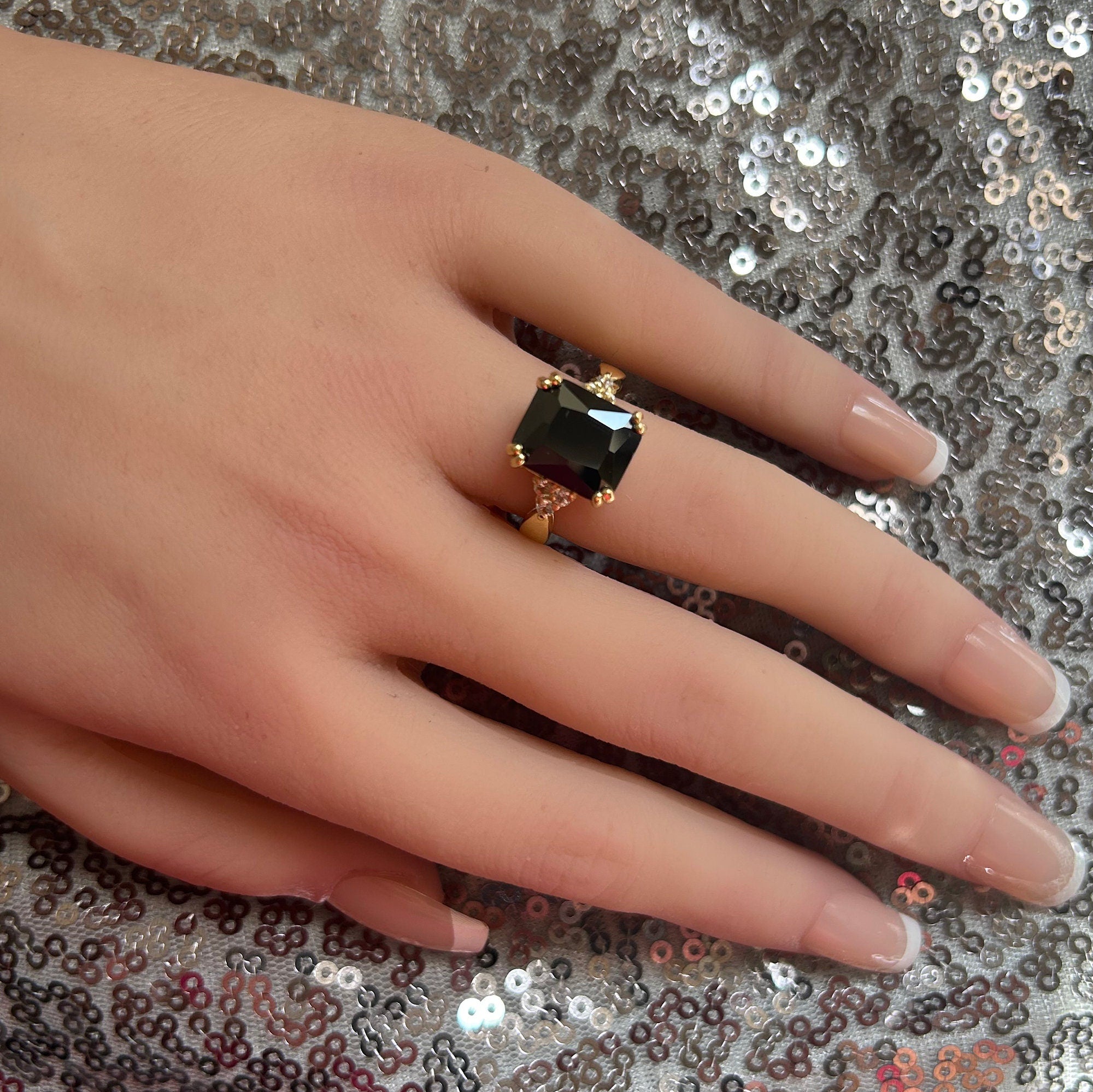 An absolute stunner, classic black onyx engagement ring with an emerald cut gemstone of your choice as it’s centre stone and with round cut clear quartz on the band to further accentuate it.