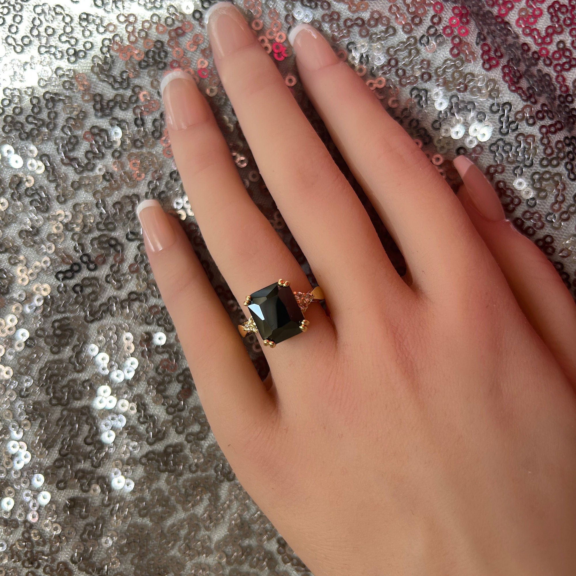 An absolute stunner, classic black onyx engagement ring with an emerald cut gemstone of your choice as it’s centre stone and with round cut clear quartz on the band to further accentuate it.