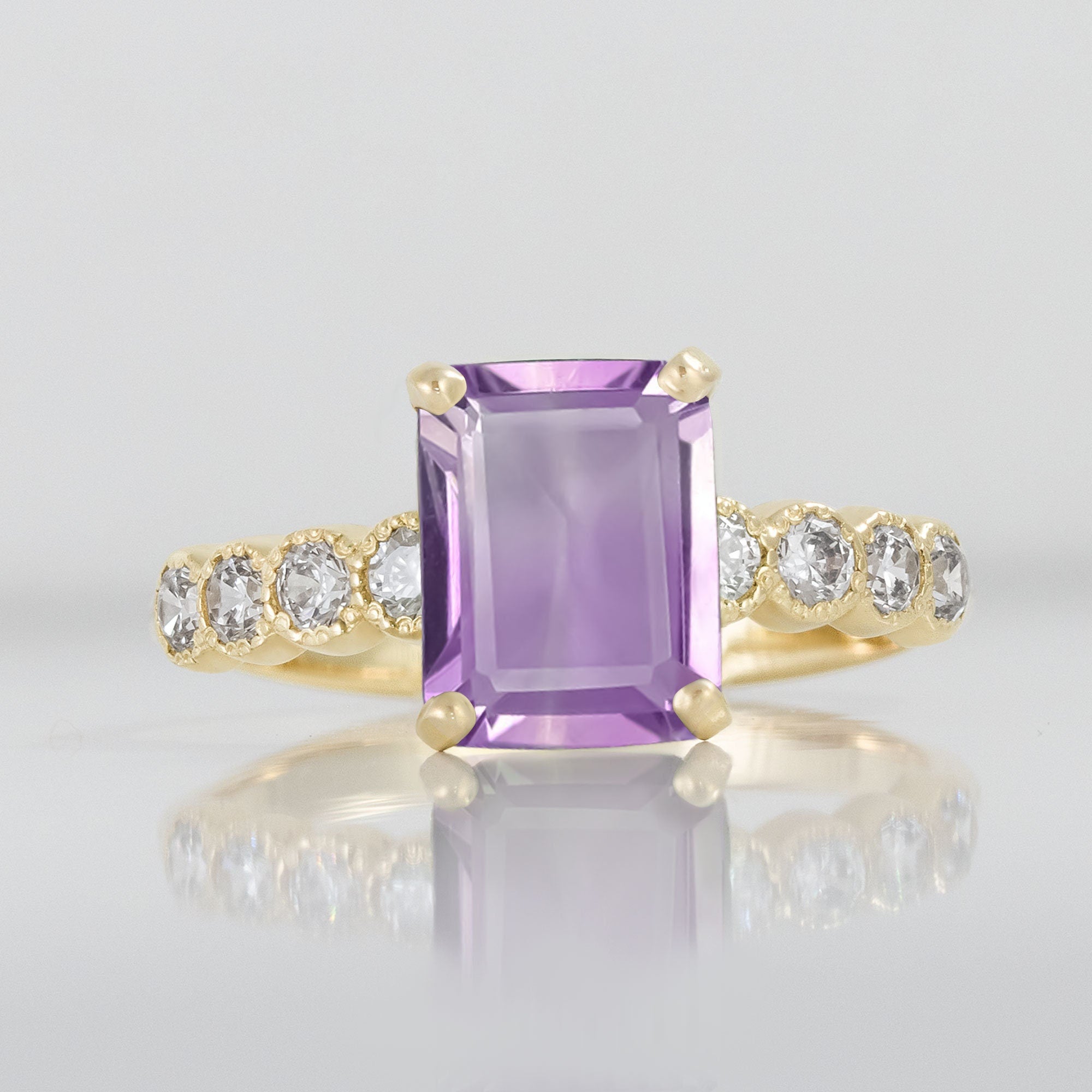 An absolute stunner, classic natural amethyst engagement ring with an emerald cut gemstone of your choice as it’s centre stone and with round cut clear quartz on the band to further accentuate it.