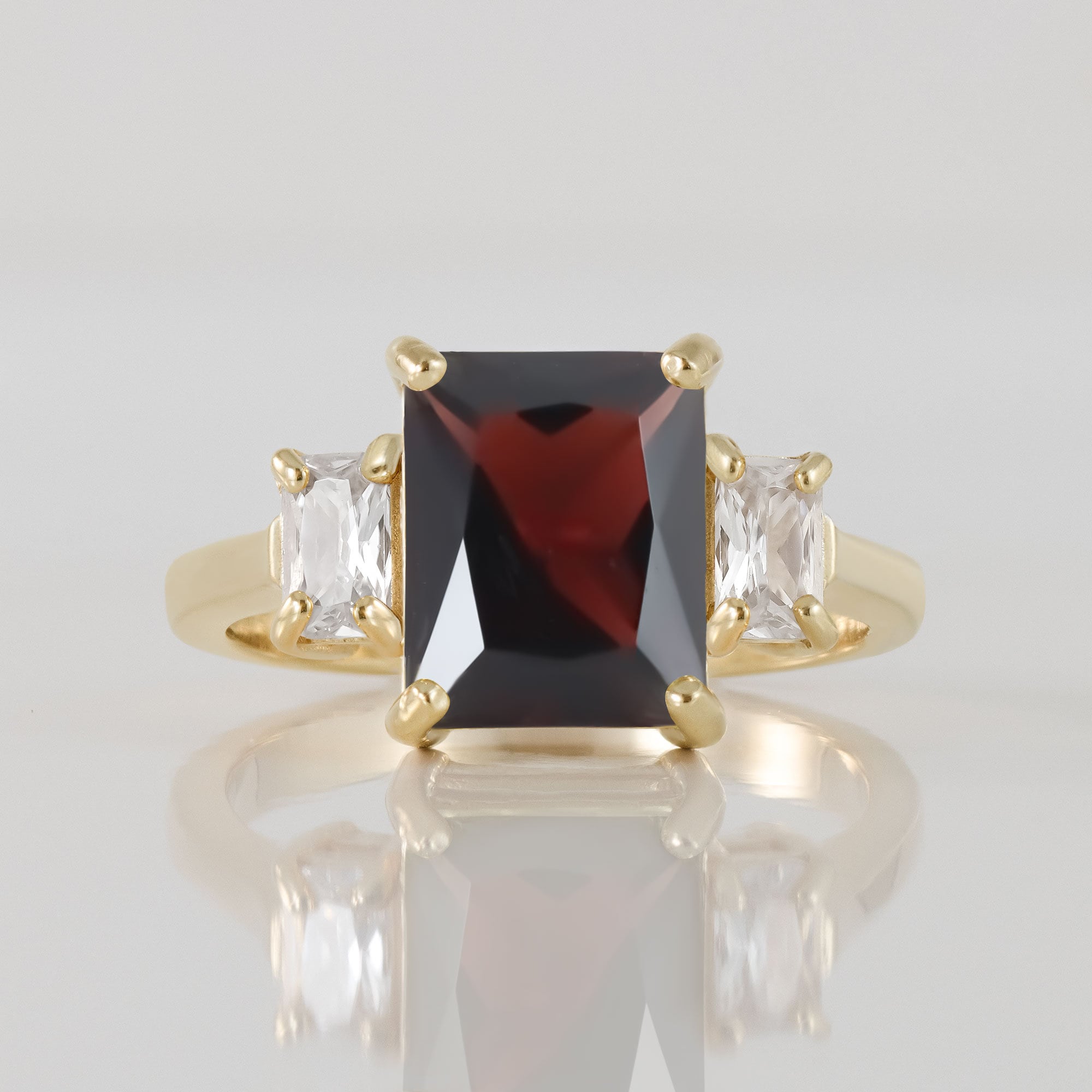 An absolute stunner, classic natural red garnet engagement ring with an emerald cut gemstone of your choice as it’s centre stone and with clear quartz on the band to further accentuate it.