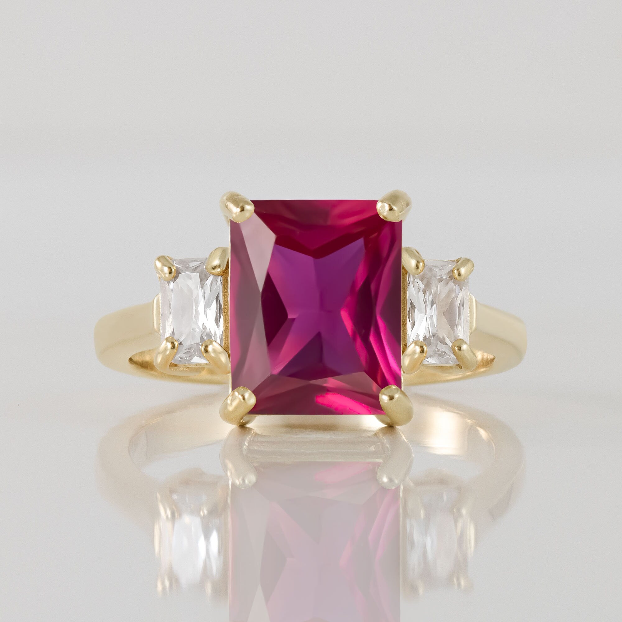 An absolute stunner, classic ruby engagement ring with an emerald cut gemstone of your choice as it’s centre stone and with clear quartz on the band to further accentuate it.