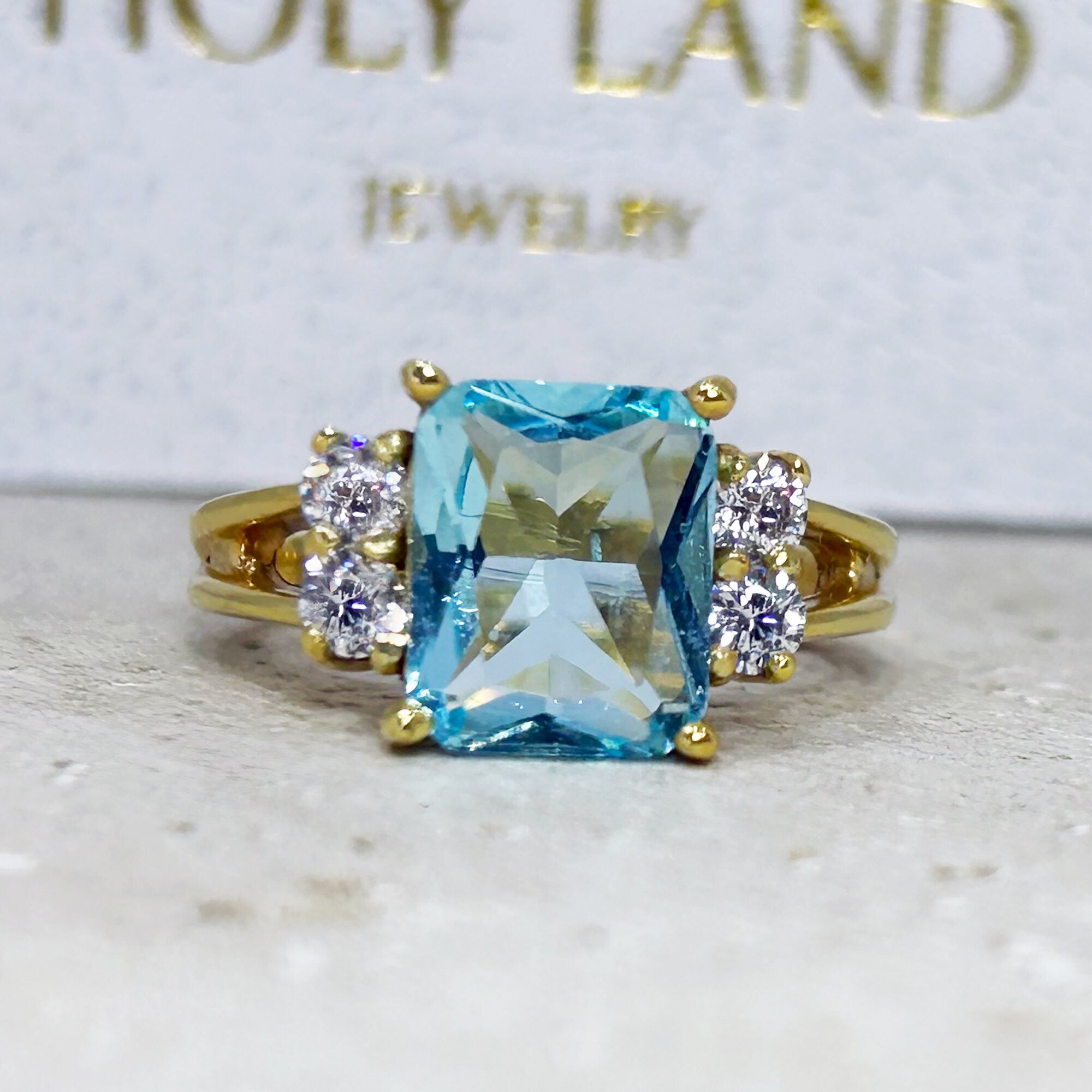 An absolute stunner, classic aquamarine engagement ring with an emerald cut gemstone of your choice as it’s centre stone and with round cut clear quartz on the band to further accentuate it.