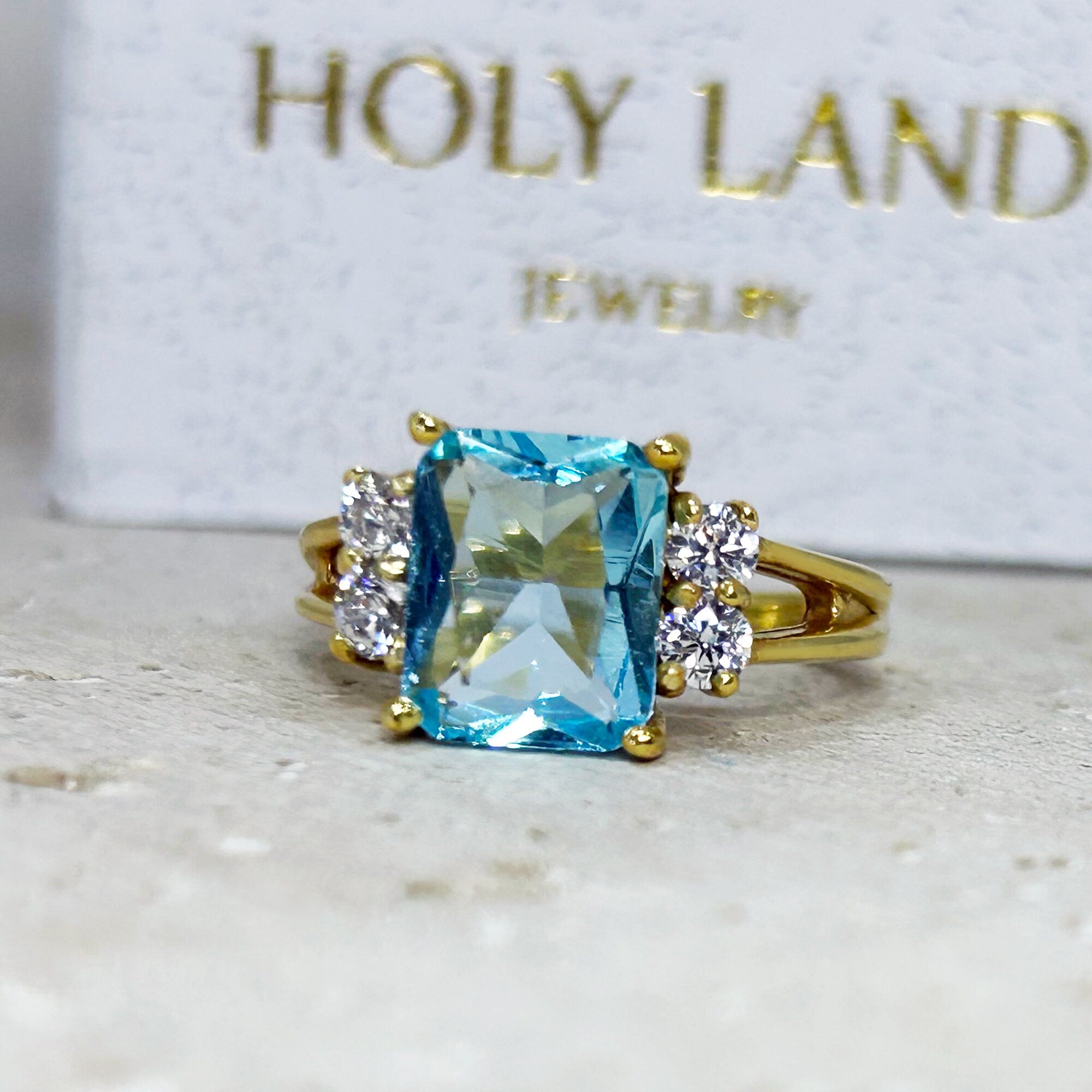 An absolute stunner, classic aquamarine engagement ring with an emerald cut gemstone of your choice as it’s centre stone and with round cut clear quartz on the band to further accentuate it.