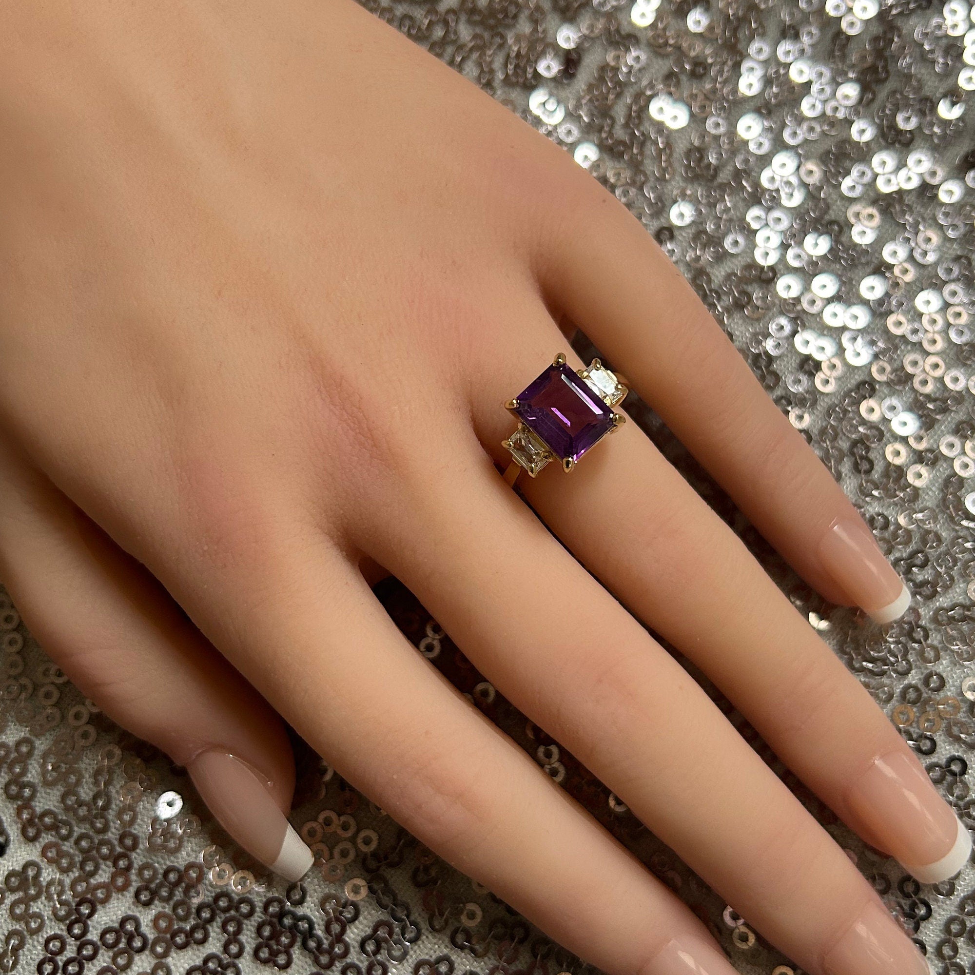 An absolute stunner, classic natural purple amethyst engagement ring with an emerald cut gemstone of your choice as it’s centre stone and with clear quartz on the band to further accentuate it.