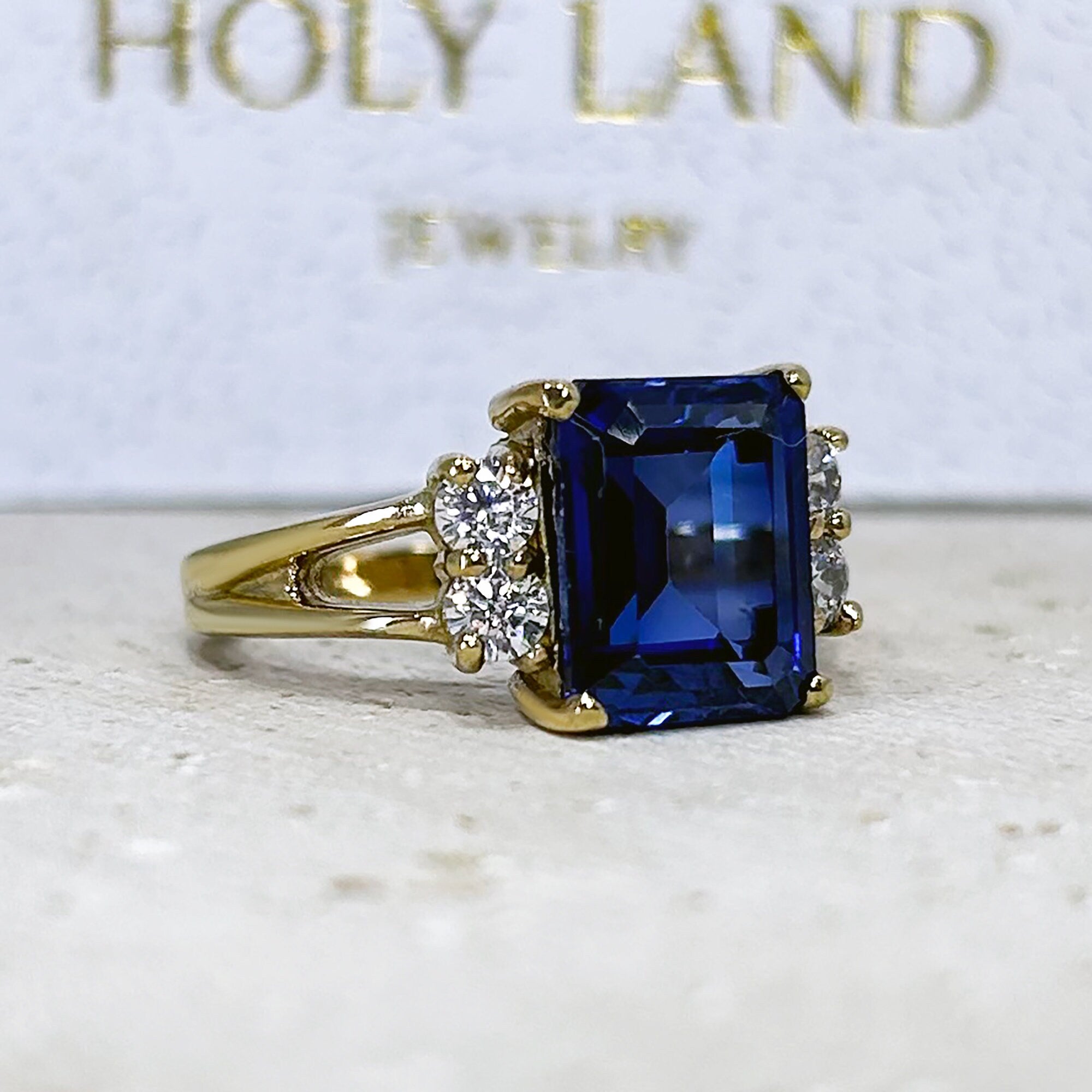 An absolute stunner, classic blue sapphire engagement ring with an emerald cut gemstone of your choice as it’s centre stone and with round cut clear quartz on the band to further accentuate it.