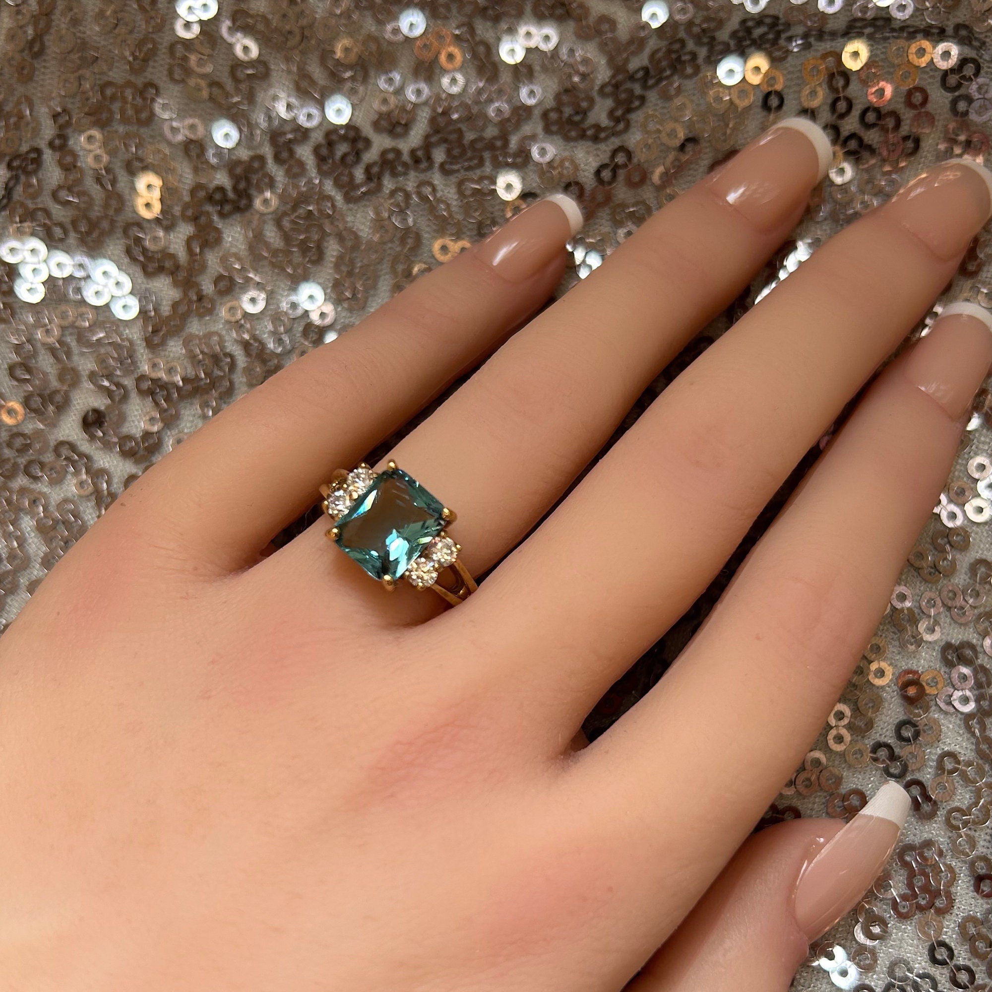 An absolute stunner, classic blue topaz engagement ring with an emerald cut gemstone of your choice as it’s centre stone and with round cut clear quartz on the band to further accentuate it.