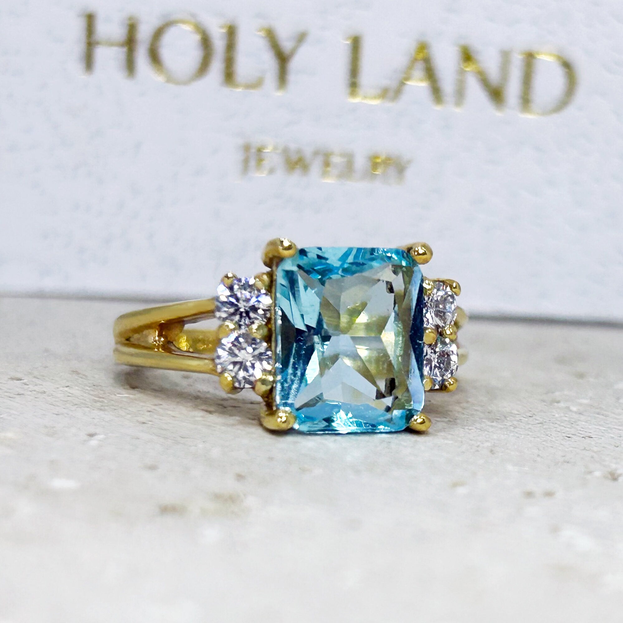 An absolute stunner, classic aquamarine engagement ring with an emerald cut gemstone of your choice as it’s centre stone and with round cut clear quartz on the band to further accentuate it.