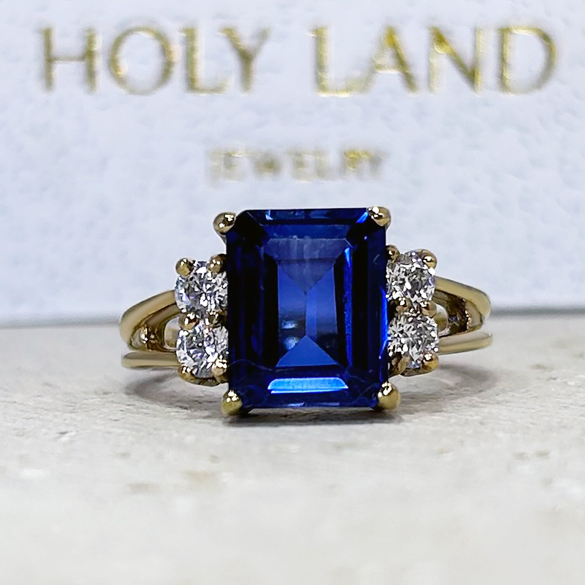 An absolute stunner, classic blue sapphire engagement ring with an emerald cut gemstone of your choice as it’s centre stone and with round cut clear quartz on the band to further accentuate it.